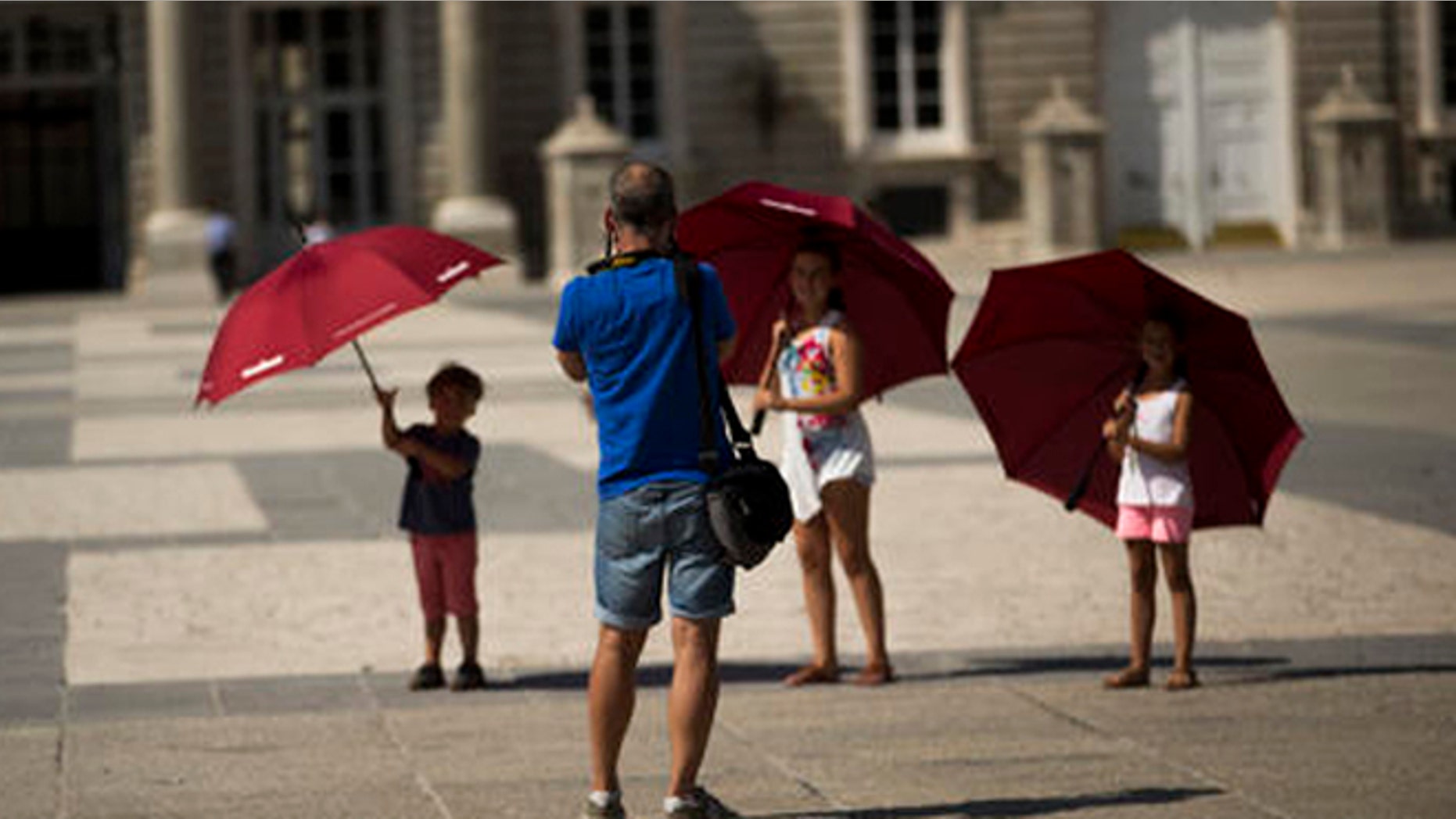 EDS NOTE : SPANISH LAW REQUIRES THAT THE FACES OF MINORS ARE MASKED IN PUBLICATIONS WITHIN SPAIN. Children pose for a photograph as they visit the Royal palace in Madrid, Spain, Friday, July 29, 2016. The number of tourists visiting Spain jumped by 12 percent in the first six months of 2016, as a mix of economic concerns and fears of extremist attacks is thought to have driven foreigners away from rival Mediterranean destinations. (AP Photo/Francisco Seco)