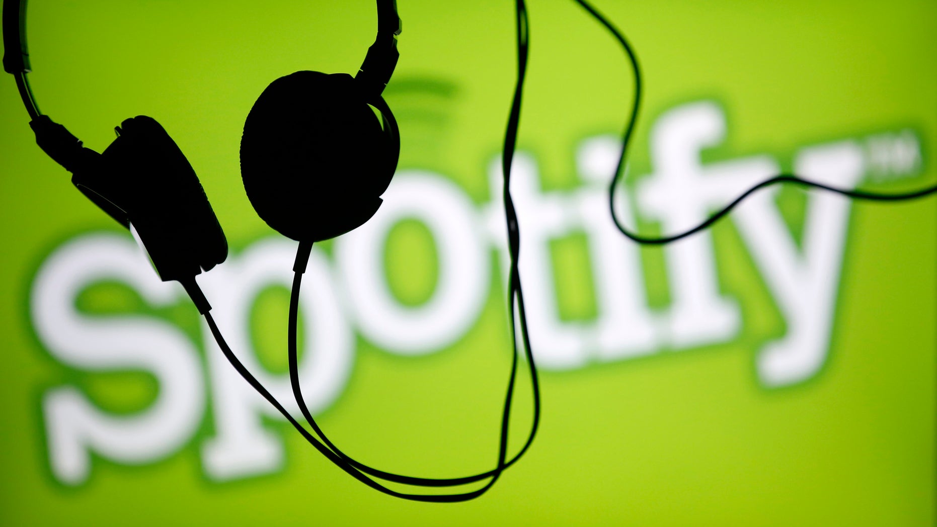 Headsets hang in front of a screen displaying a Spotify logo on it, in Zenica February 20, 2014. Online music streaming service Spotify is recruiting a U.S. financial reporting specialist, adding to speculation that the Swedish start-up is preparing for a share listing, which one banker said could value the firm at as much as $8 billion (4 billion pounds). REUTERS/Dado Ruvic (BOSNIA AND HERZEGOVINA - Tags: SCIENCE TECHNOLOGY BUSINESS SOCIETY) - RTX1975T