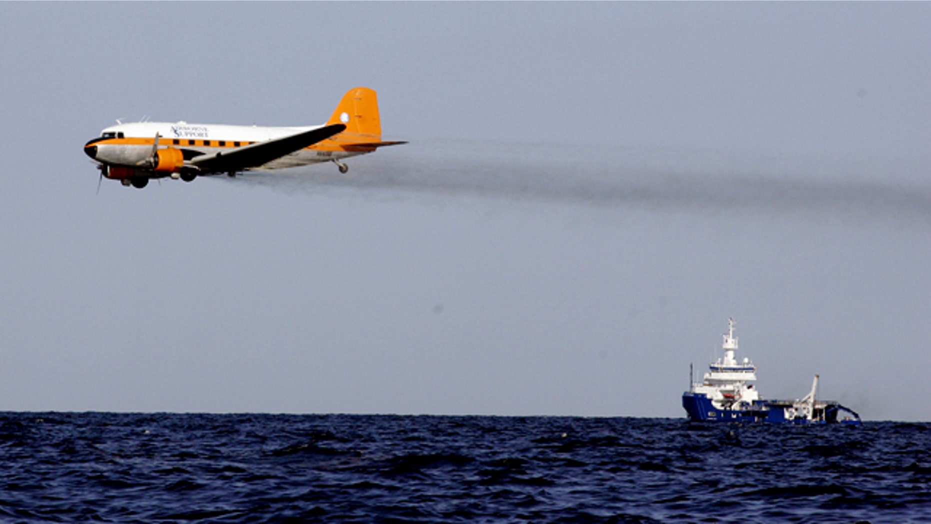 A dispersant plane passes over an oil skimmer as it cleans oil from a leaking pipeline that resulted from last week's explosion and collapse of the Deepwater Horizon oil rig in the Gulf of Mexico near the coast of Louisiana Tuesday, April 27, 2010.