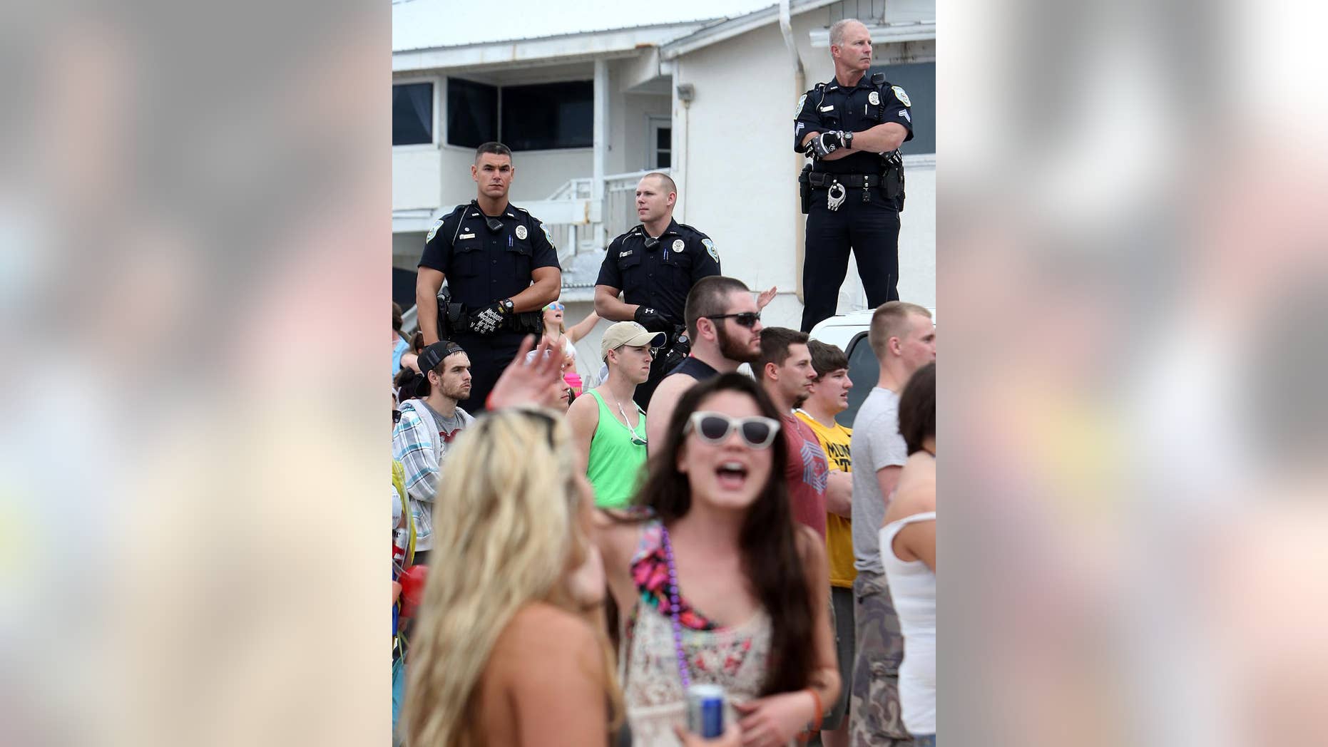 FILE - This March 11, 2014 file photo shows Panama City Beach Police Officers watching over a large crowd of spring breakers during a Luke Bryan concert in Panama City, Fla. (AP Photo/The News Herald/Panama City, Fla., Andrew Wardlow)
