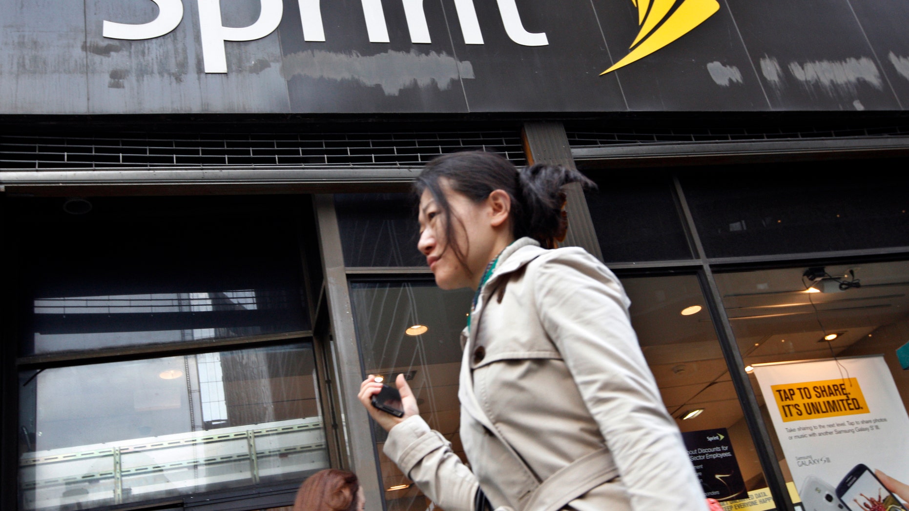 A woman walks past a Sprint store in New York's financial district, October 15, 2012.