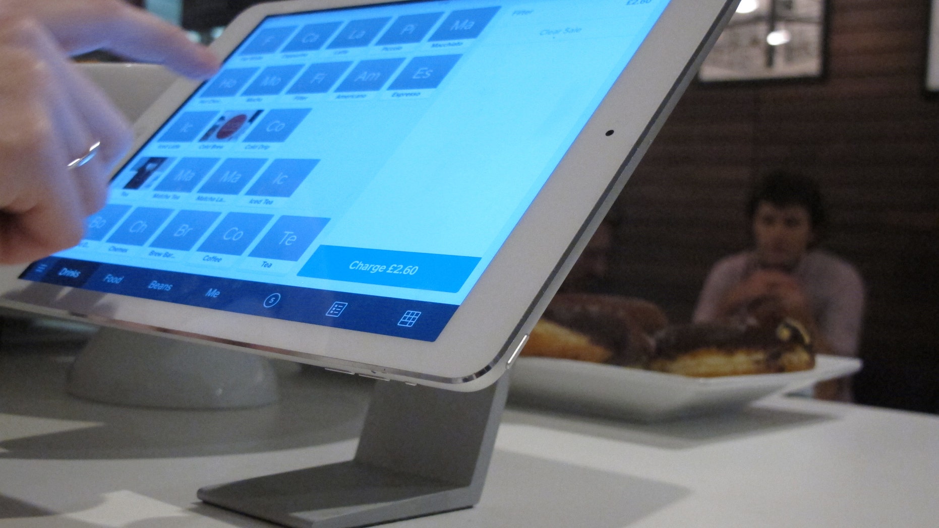 Catherine Seay demonstrates the use of Square point-of-sale software at the Curators Coffee Gallery in central London.