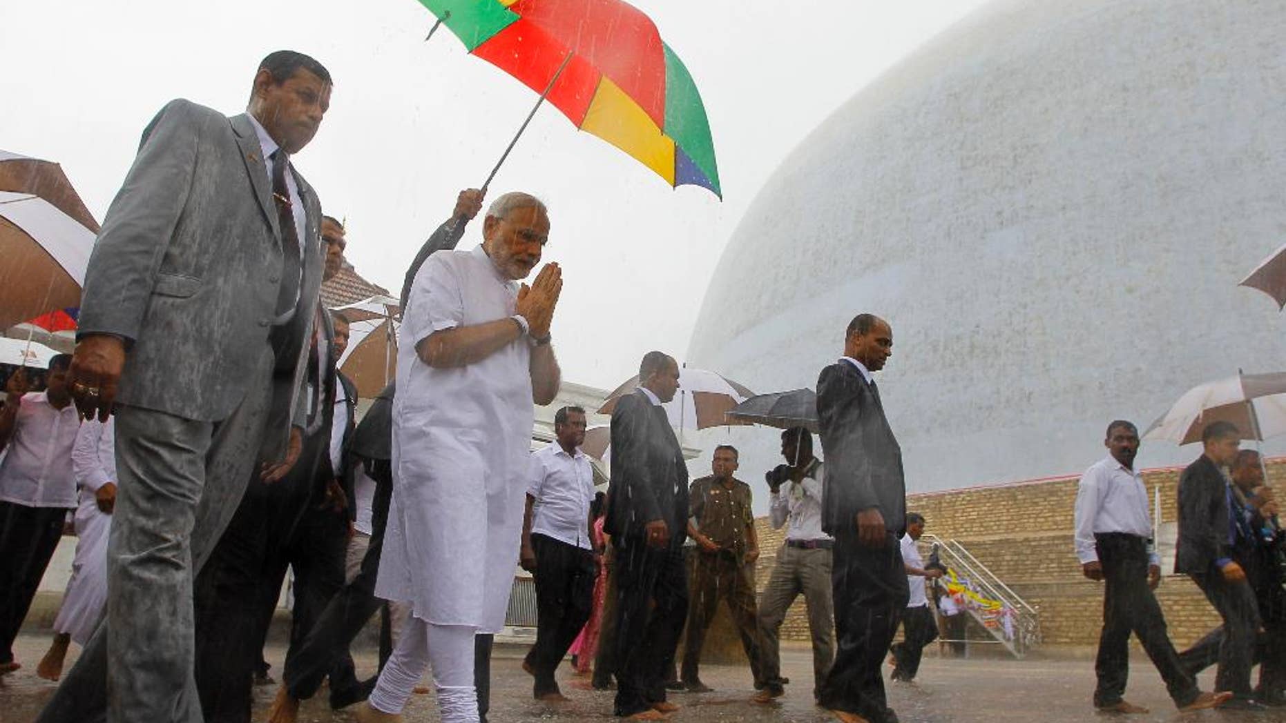 Indian Prime Minister Narendra Modi folds his hands in a sign of respect during his visit to Ruwanwelisaya, a sacred stupa in Anuradhapura, about 230 kilometers northeast of Colombo, Sri Lanka, Saturday, March 14, 2015. Modi said on Friday that India's neighbors should be the first beneficiaries of the nation's economic progress as he sought to woo smaller Indian Ocean states away from increasing Chinese influence. (AP Photo/Eranga Jayawardena)