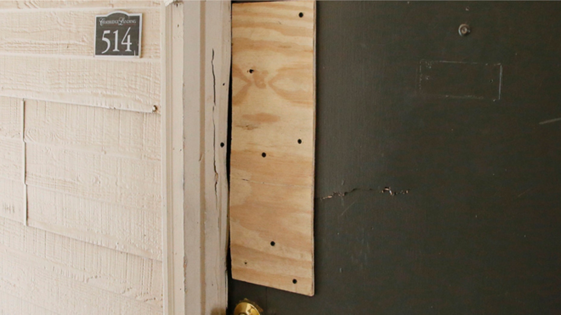 The boarded-up door of an apartment where Oklahoma City police have arrested a mother on suspicion of stabbing a man and her two children, the youngest of which was pronounced dead when police arrived on scene, is pictured in Oklahoma City, Monday, July 11, 2016. (AP Photo/Sue Ogrocki)