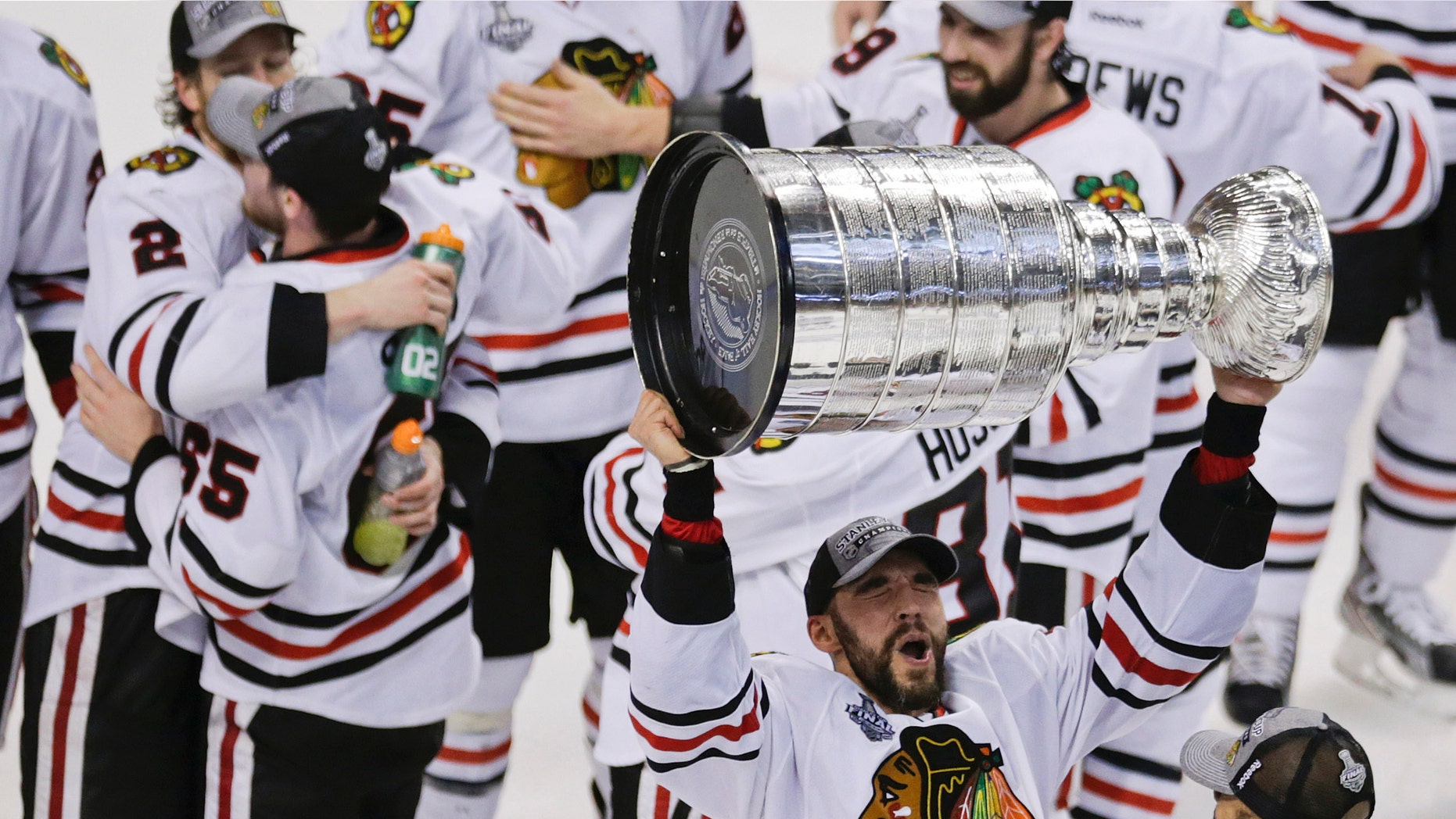 Chicago Blackhawks defenseman Michal Rozsival, of the Czech Republic, hoists the Stanley Cup after the Blackhawks beat the Boston Bruins 3-2 in Game 6 of the NHL hockey Stanley Cup Finals Monday, June 24, 2013, in Boston. (AP Photo/Charles Krupa)