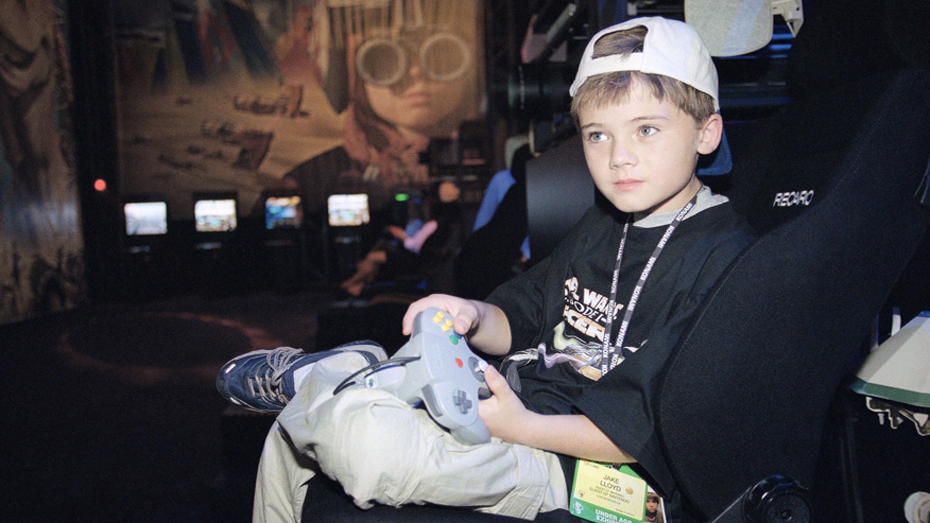 FILE- In this May 13, 1999, file photo, actor Jake Lloyd; who portrays young Anakin Skywalker in the film "Star Wars Episode I: The Phantom Menace;" plays a game during the Electronic Entertainment Expo in Los Angeles.