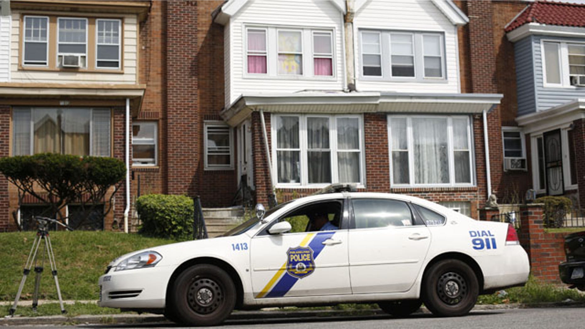September 9, 2013: A police officer sits outside the home of a severely disabled 3-year-old girl who was pronounced dead at a nearby hospital in Philadelphia. Nathalyz Rivera, a twin, weighed just 11 pounds when she died and police in Philadelphia called her death a homicide. (AP Photo/Matt Rourke)