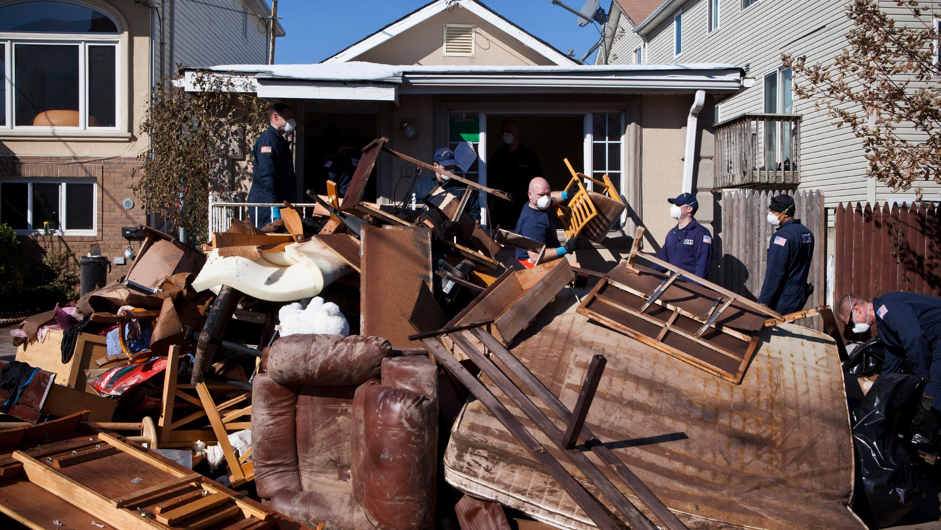 Members of the United States Coast Guard help clear a house in the Midland Beach neighborhood, on Staten Island, N.Y. Nov. 9, 2012. (REUTERS/Andrew Burton)