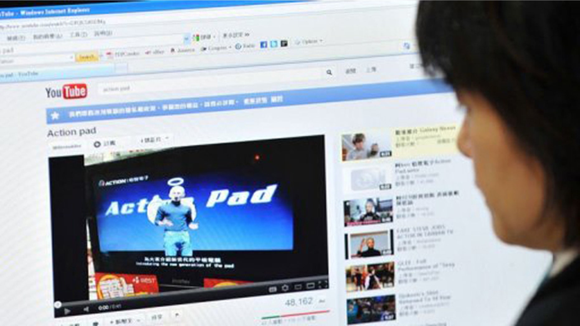 A woman looks at an Internet website in Taipei showing Taiwanese comedian A-Ken dressed up as Apple's late founder.