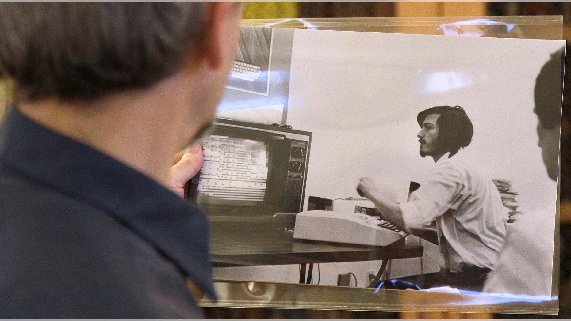 Oct. 25, 2011: Curator Henry Lowood looks at an old photograph of Steve Jobs at Stanford's Green Library in Stanford, Calif. Historians and entrepreneurs who want to understand the rise of Apple Inc. and its founder Steve Jobs will find a treasure trove of clues in the Silicon Valley Archives.