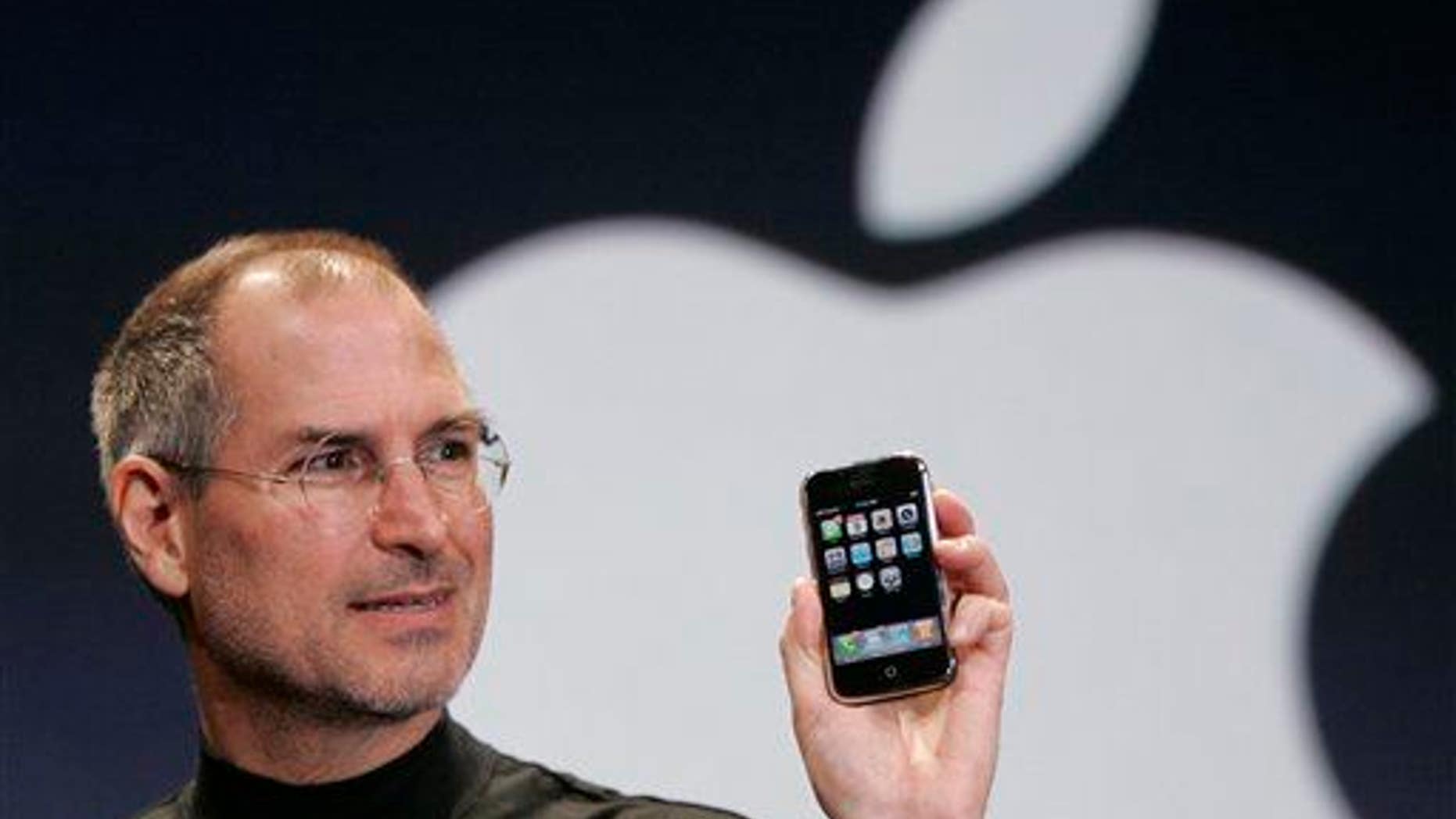 Apple CEO Steve Jobs holds up an Apple iPhone at the Macworld conference in San Francisco on Jan. 9, 2007.