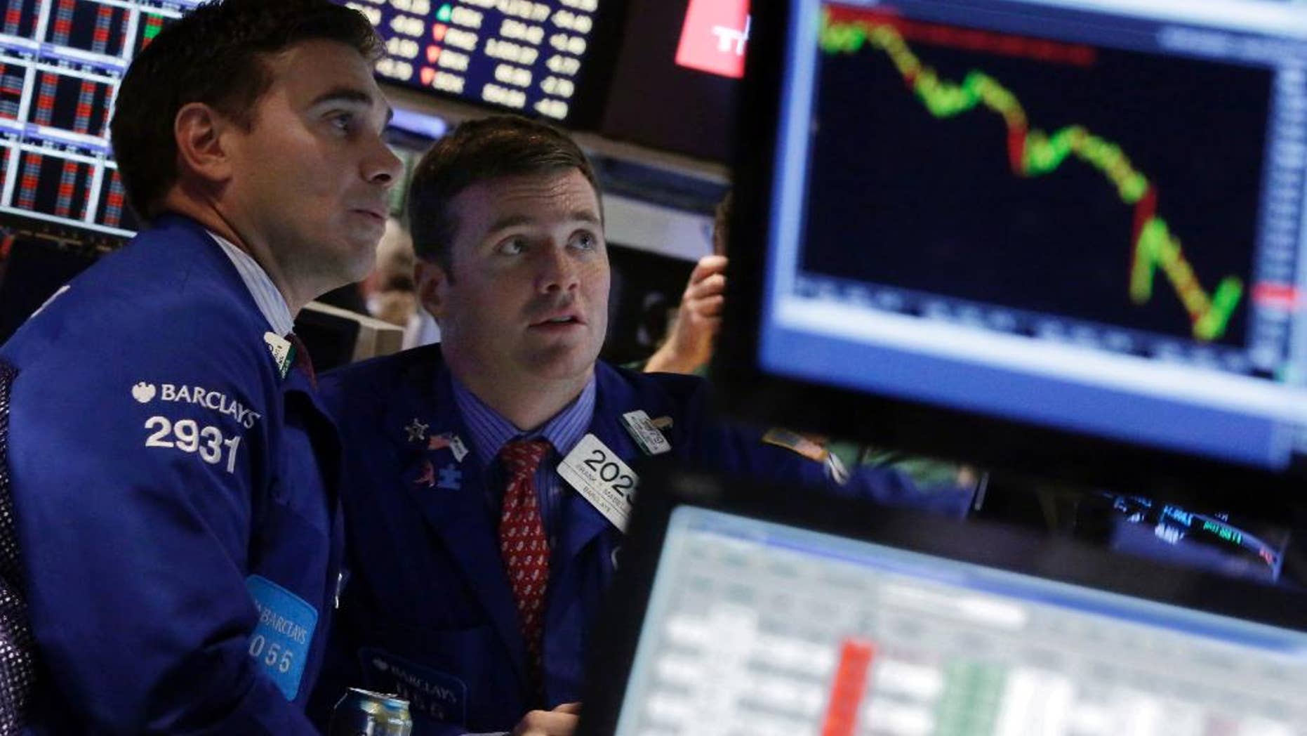 FILE - In this Oct. 15, 2014 file photo, specialists Robert Tuccillo, left, and Frank Masiello work on the floor of the New York Stock Exchange. The biggest stock slump in more than two years is no reason to abandon the market, professional investors and strategists say. (AP Photo/Richard Drew, File)