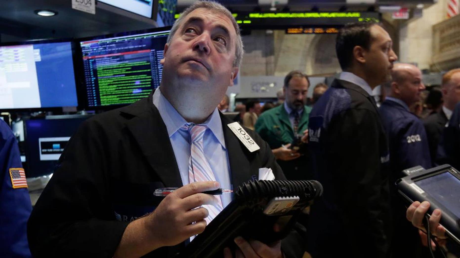 FILE - In this Thursday, Aug. 21, 2014, file photo, trader Edward McCarthy, left, works on the floor of the New York Stock Exchange. As stocks continue to rise, investors are wondering if it’s time to sell. (AP Photo/Richard Drew, File)