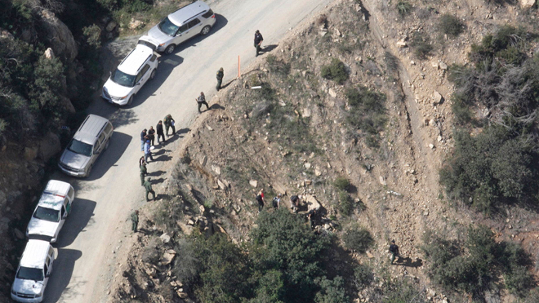 This aerial photo shows the scene of a shooting by a U.S. Border Patrol agent near San Diego on Tuesday, Feb. 18, 2014. Investigators say a man who was shot and killed by a U.S. Border Patrol agent near San Diego threw several large rocks at the agent, including one the size of a basketball. The San Diego County Sheriff's Department said Wednesday that the attacker began throwing fist-sized rocks at the agent from a hillside perch. The rocks got larger, and one of the bigger pieces hit the agent in the head. The sheriff's department says the agent fired his gun twice Tuesday, fearing that he might be killed or incapacitated if he was hit again. The agent was treated for minor injuries at a hospital and released. (AP Photo/U-T San Diego, John Gibbins) NO SALES; COMMERCIAL INTERNET OUT