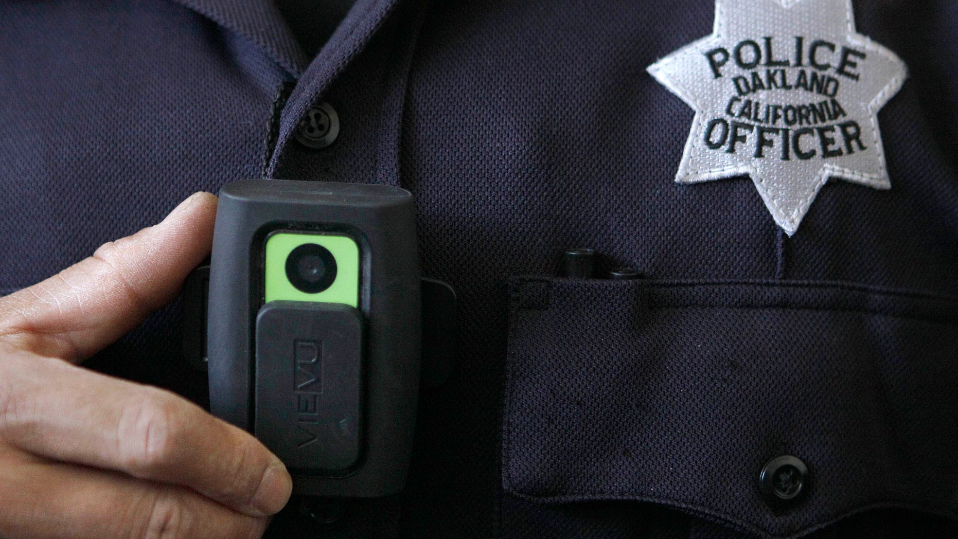 In this June 16, 2011 file photo, Oakland Police officer Huy Nguyen shows a video camera worn by some officers in Oakland, Calif. A judge who slammed New York City's stop-and-frisk program as discriminatory has suggested a pilot program in which officers wear cameras on their uniforms to record street encounters. (AP Photo/Jeff Chiu, file)