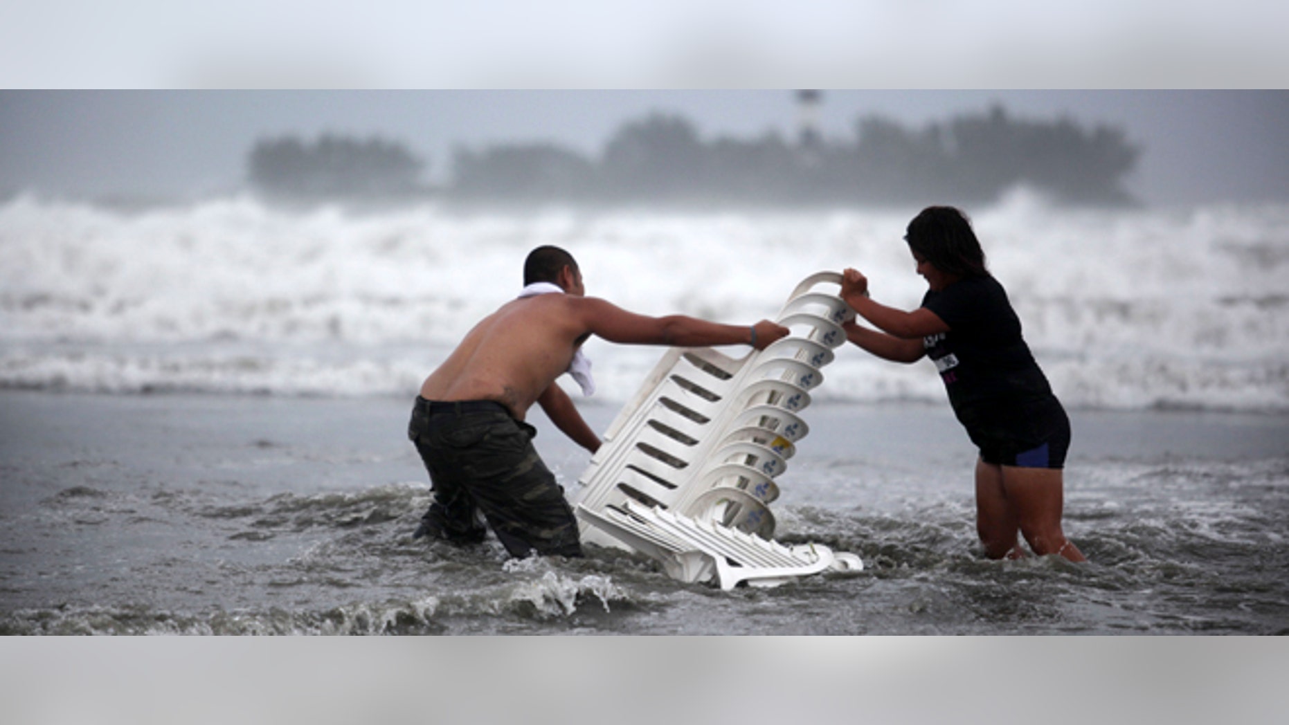 Vendors that were caught unprepared try to recover their chairs after high waves dragged their beach stalls into the sea in Veracruz, Mexico, Thursday Aug. 9, 2012. Tropical Storm Ernesto headed into Mexico's southern Gulf coast as authorities in the flood-prone region prepared shelters, army troops and rescue personnel for drenching rains. (AP Photo/Felix Marquez)