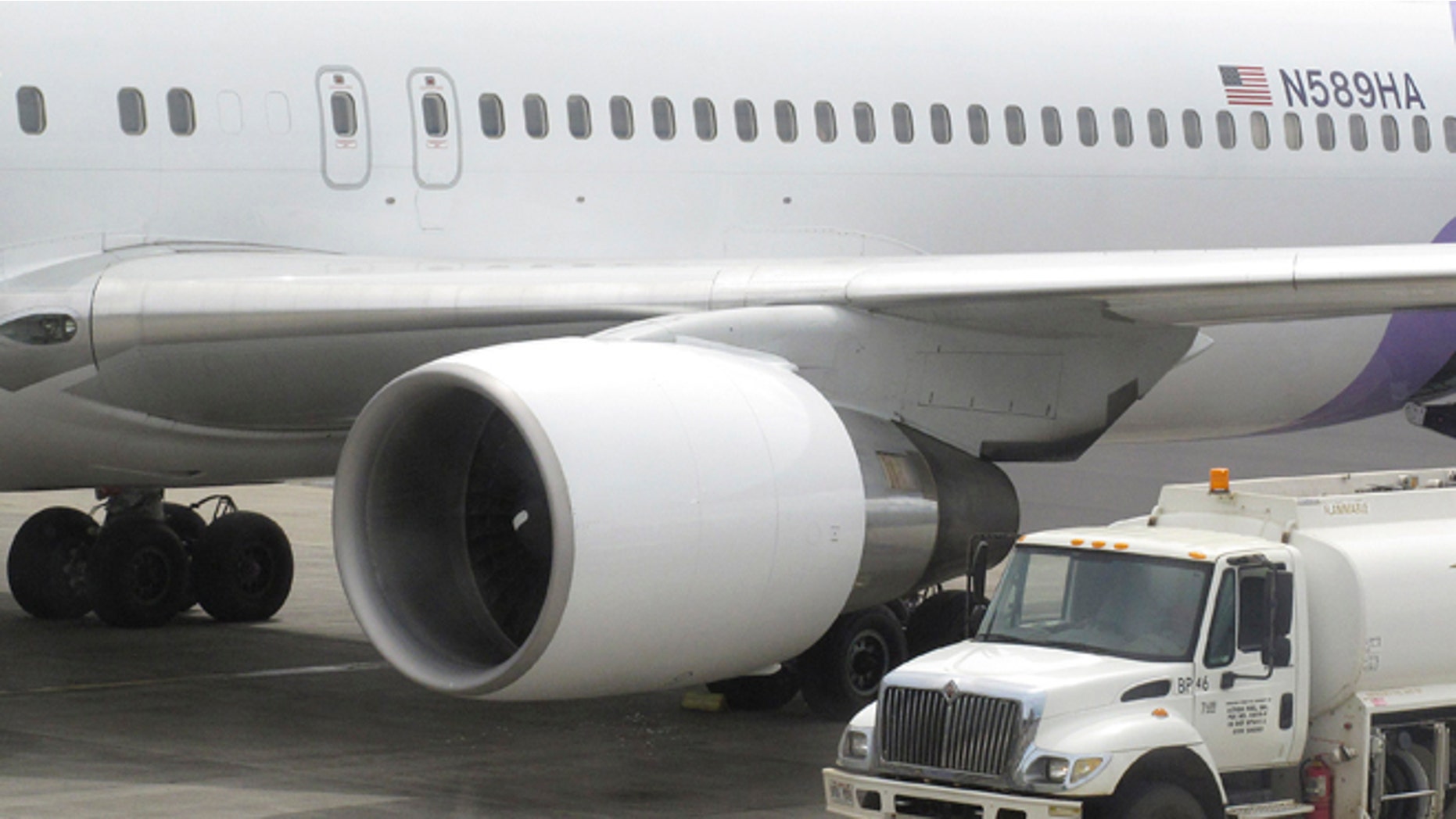 Hawaiian Airlines Flight 45 arrives from San Jose, Calif., in Kahului Airport in Kahului, Hawaii, on Monday, April 21, 2014. A 15-year-old boy on Sunday scrambled over an airport fence, crossed a tarmac and climbed into a jetliner's wheel well, then flew for five freezing hours to Hawaii on a misadventure that forced authorities to take a hard look at the security system that protects the nation's airline fleet. (AP Photo/Oskar Garcia)