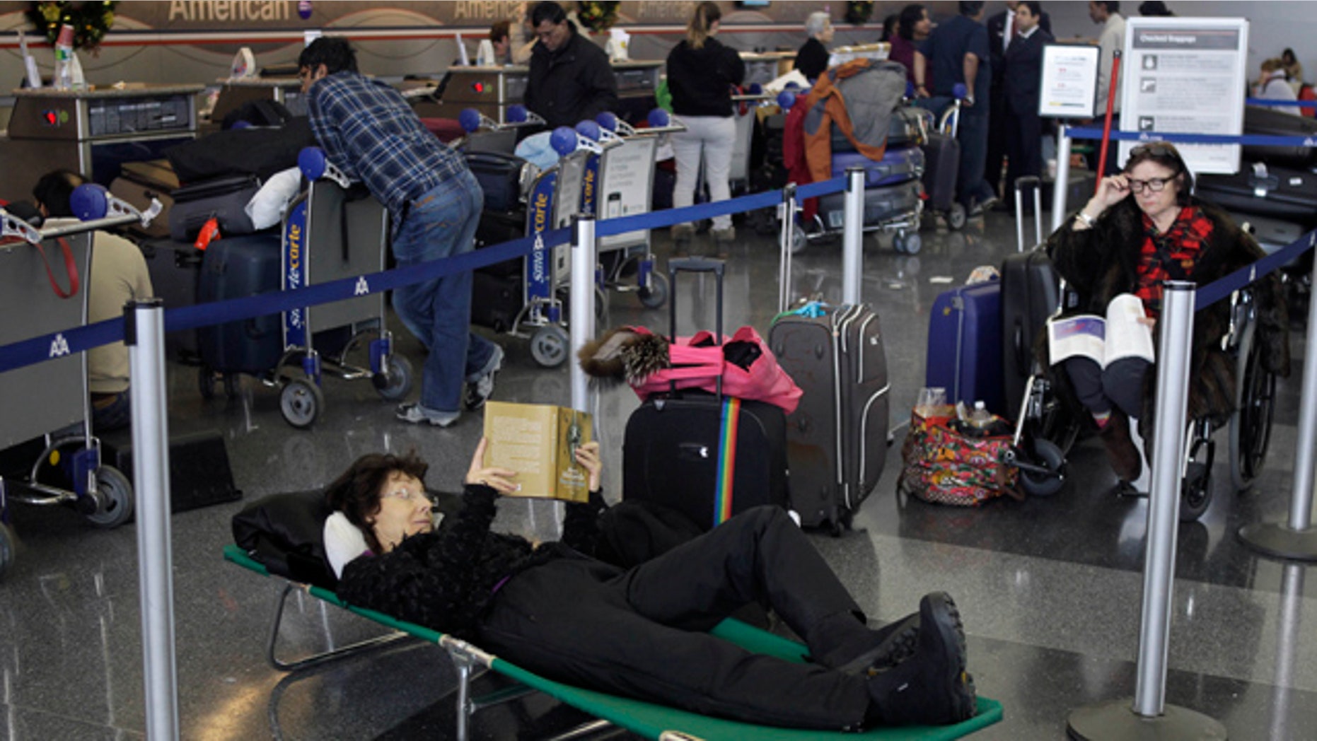 Dec. 27, 2010: Air passengers that stayed overnight in the airport pass the time while waiting for news of their canceled flights at John F. Kennedy International Airport in New York.