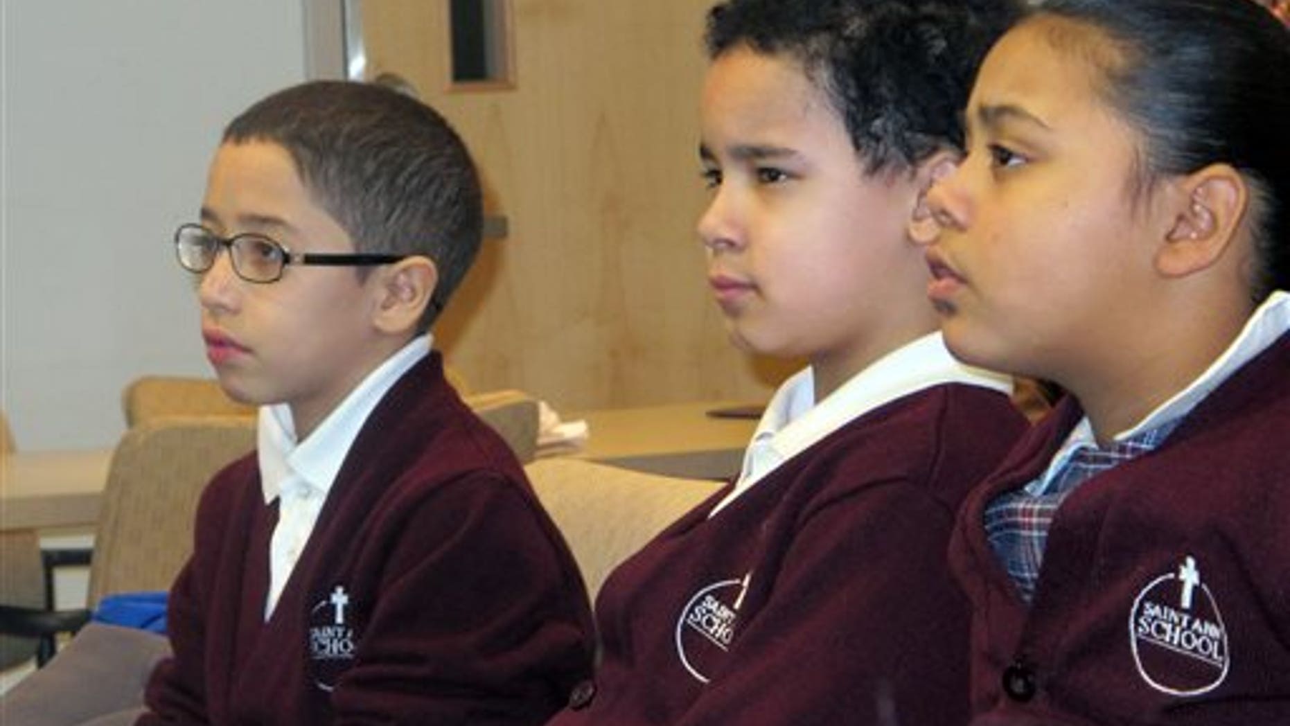 In this Feb. 25, 2014 photo, third-graders, from left, Jan Carlos Medina, Matthew Velez and Natalie Mieses take in a class that teaches them about stroke on Feb. 25, 2014, at Montefiore Hospital in the Bronx, N.Y. The hospital educates children to recognize stroke and get victims to a hospital quickly. (AP Photo/Jim Fitzgerald)