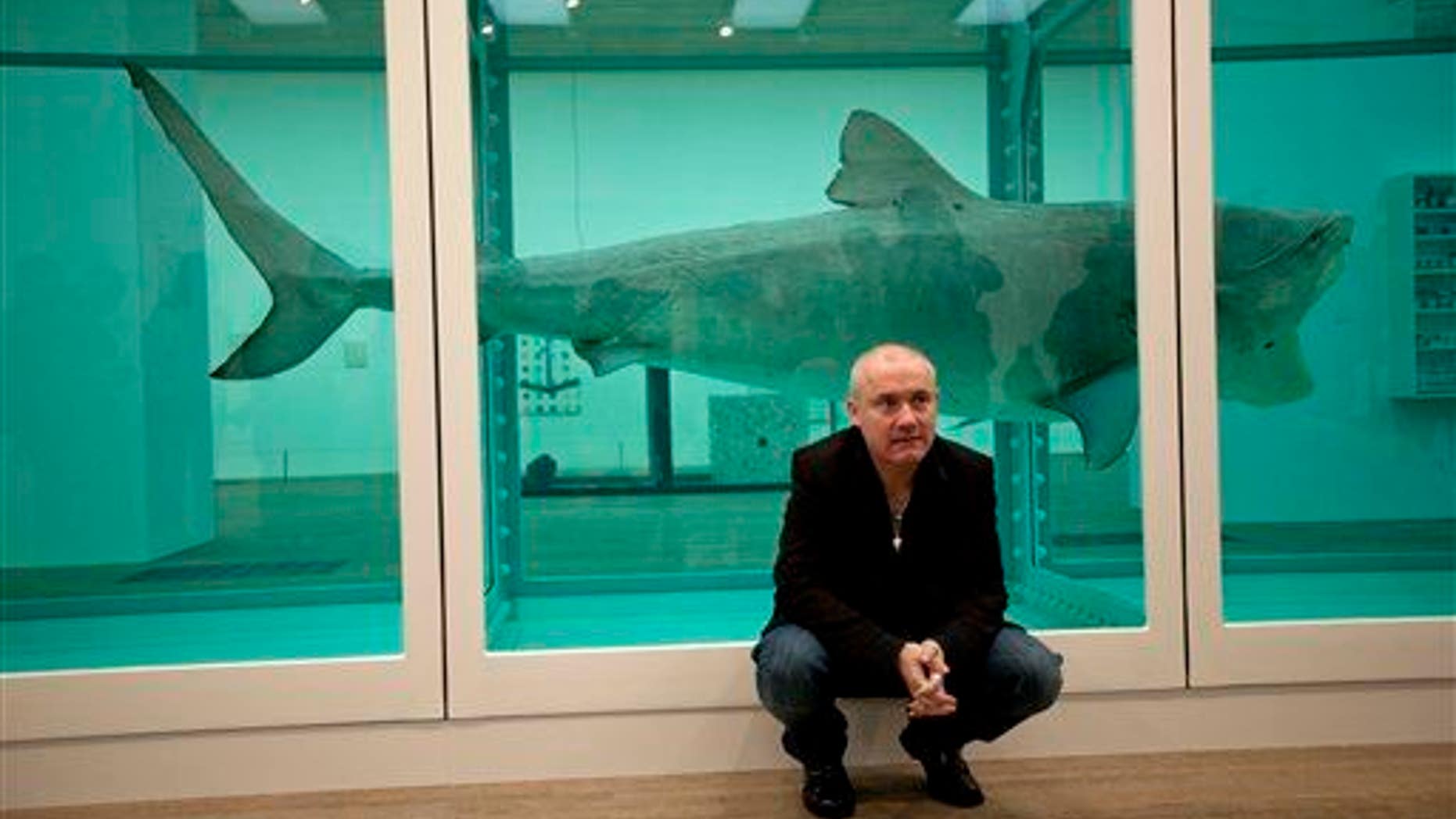 Damien Hirst poses beside his piece "The Physical Impossibility of Death in the Mind of Someone Living" in 2012 at the Tate. Death was actually not so impossible, as a new study finds the piece was leaking poisonous gas.