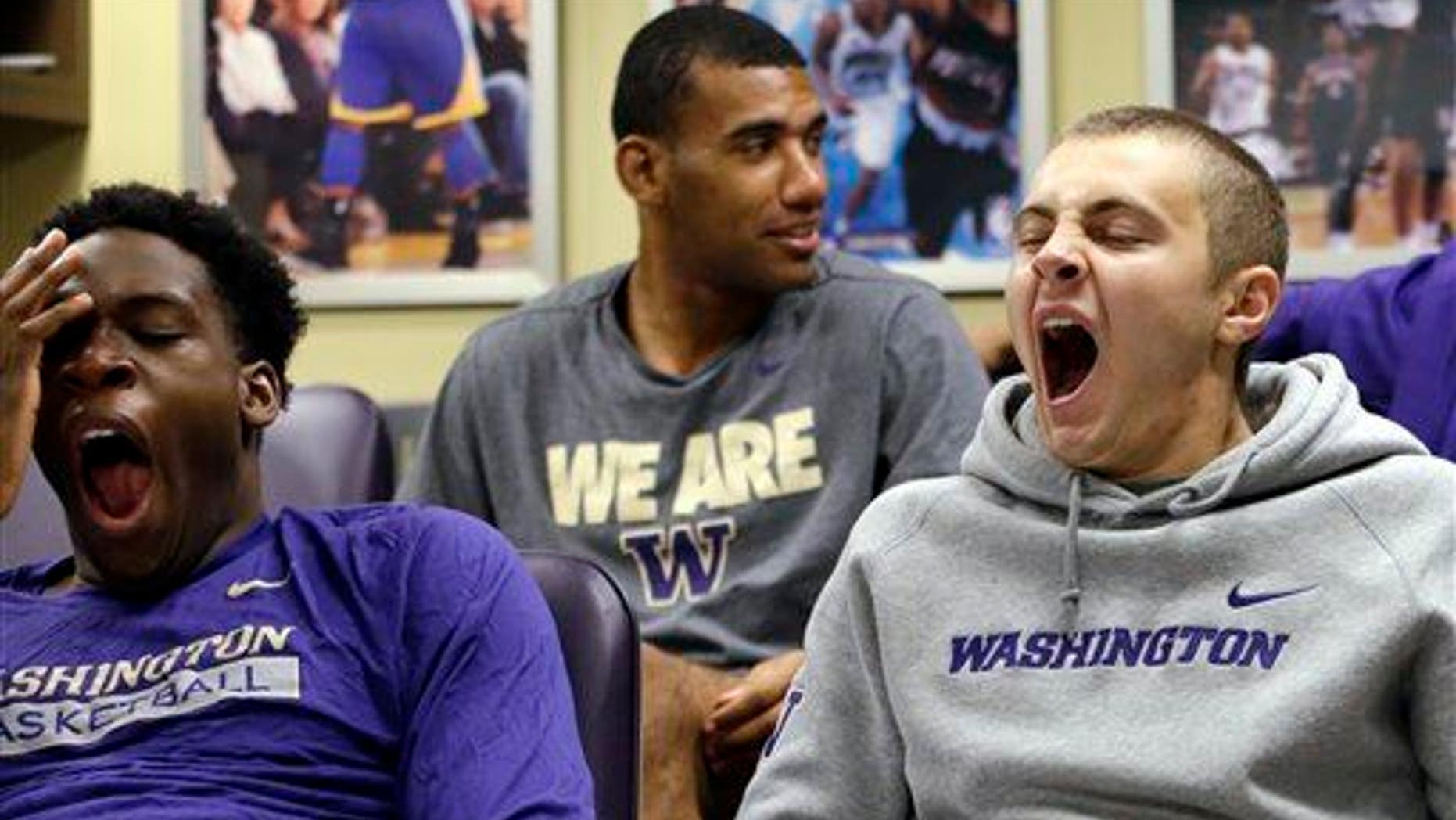 In this photo taken Sept. 28, 2015, Washington men's basketball players yawn as a classmate sits behind them during a class in Seattle.