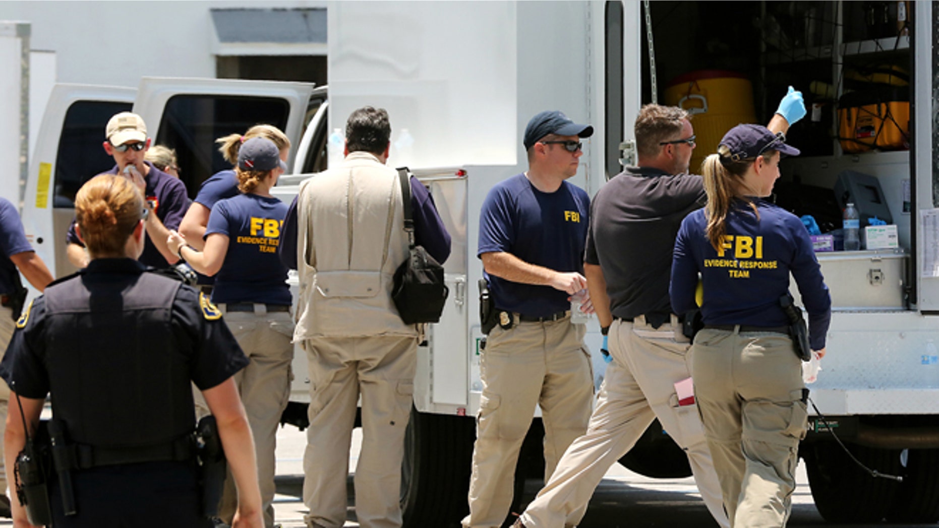 In this photo taken on Monday, July 27, 2015, federal agents and Key West Police gather in a restaurant parking lot in Key West, Fla. A man described by the FBI as an Islamic State sympathizer who hoped to mount attacks on U.S. soil was charged Tuesday with plotting to detonate a nail-filled backpack bomb on a Florida beach. (Rob O'Neal/The Key West Citizen via AP) MIAMI OUT; MANDATORY CREDIT