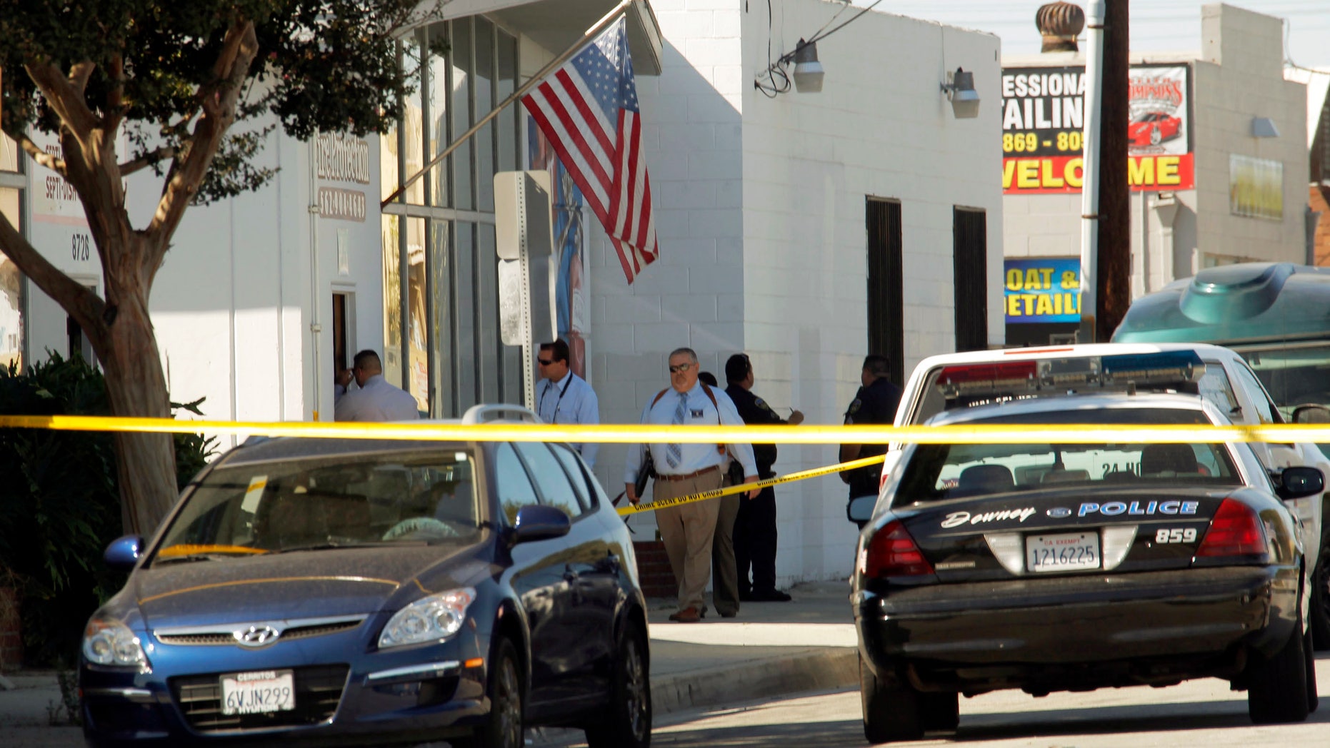 Oct. 24, 2012: Police investigators stand outside a family-owned business, United States Fire Protection Services, in Downey, Calif. Five people were shot and at least two died in shootings at the business and a residence in the Los Angeles suburb Wednesday, according to Downey police Lt. Dean Milligan.