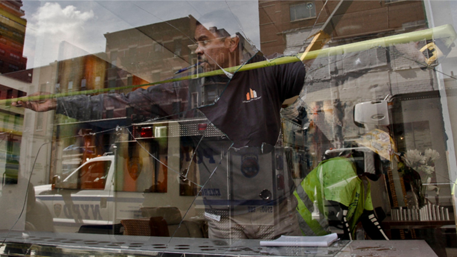 Aug. 21, 2012: A workers measure the area of a shattered window at the Kolb Art Gallery following damage from an intentional underground explosion on the Second Avenue subway project on East 72nd Street.