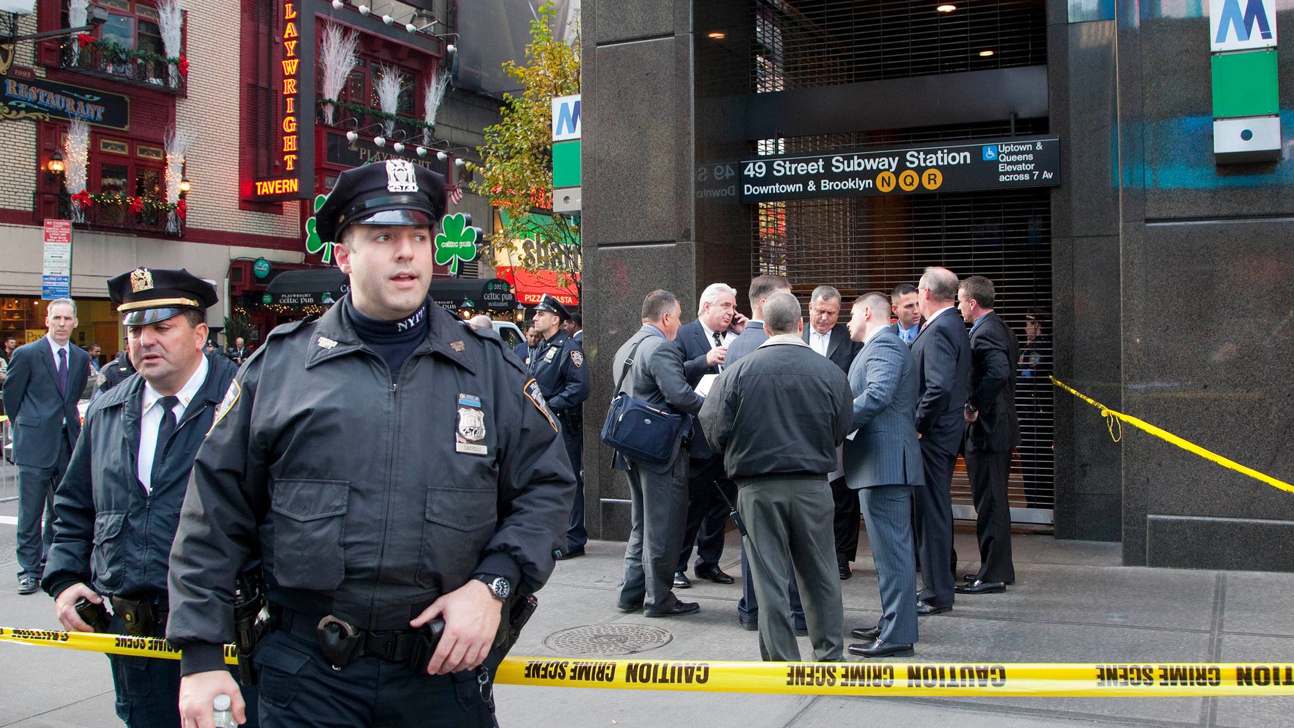 Dec. 3, 2012: Uniformed and plainclothes police officers stand outside a New York subway station after a man was killed after falling into the path of a train. Transit officials say police are investigating whether he could have been pushed onto the tracks.