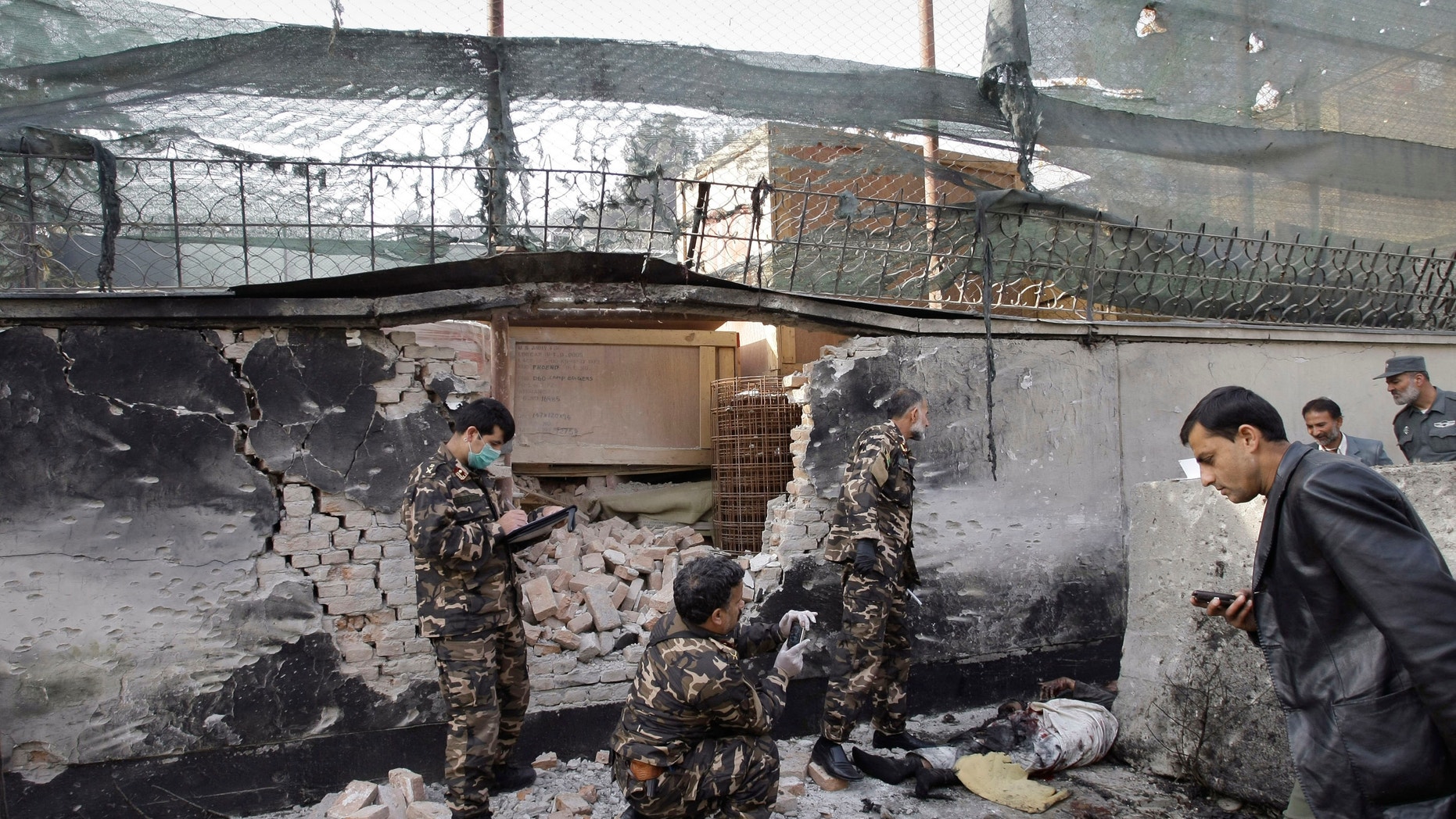 Nov. 21, 2012: Afghan security men inspect the scene of a suicide attack in Kabul, Afghanistan.