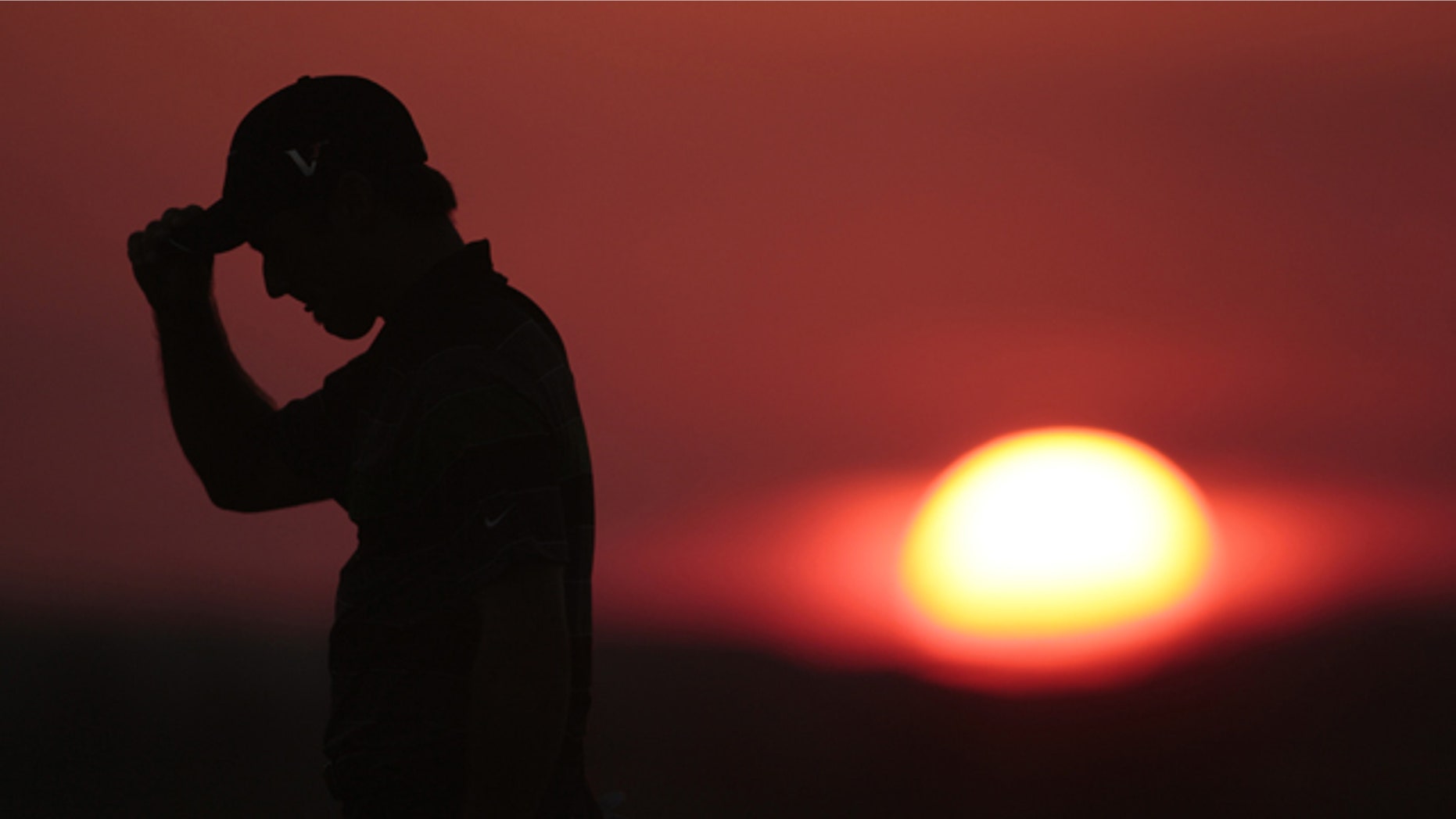 Trevor Immelman of South Africa walks off the 10th hole as the sun sets during the first round of the PGA Championship golf tournament Thursday, Aug. 12, 2010, at Whistling Straits in Haven, Wis. (AP Photo/Charlie Riedel)