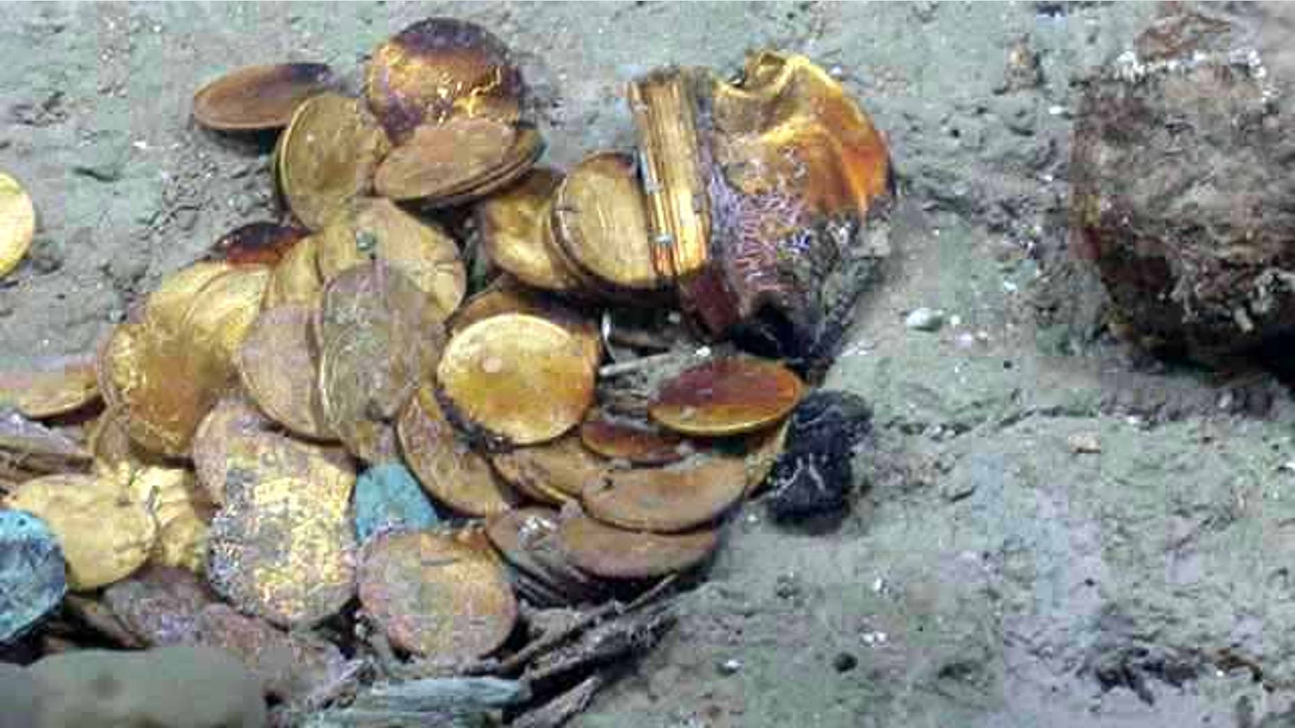 Gold coins and a gold box lie in situ on the "Black Swan" site. Hundreds of gold coins and more than 500,000 silver coins were discovered on the site.