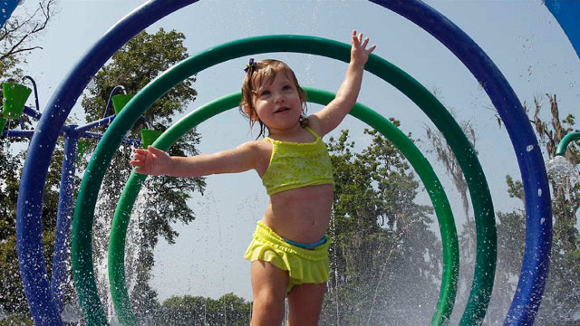 FILE: Alivia Parker, 21 months, runs through circles of spraying water on a 100 degree day in Montgomery, Ala.