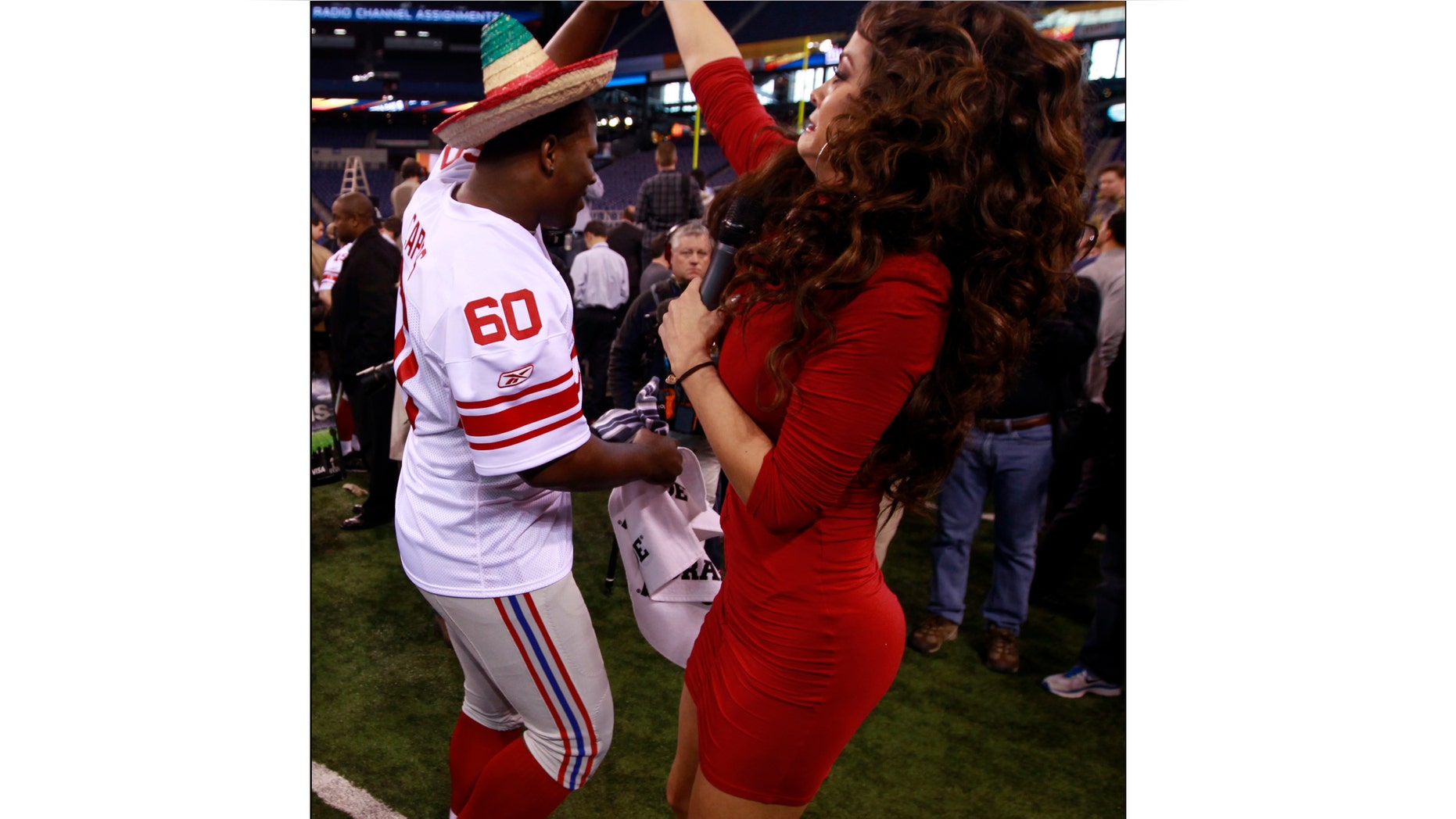 Marisol Gonzalez, Televisa reporter, dances with Selvish Capers of the Giants, Jan. 31, 2012, in Indianapolis.