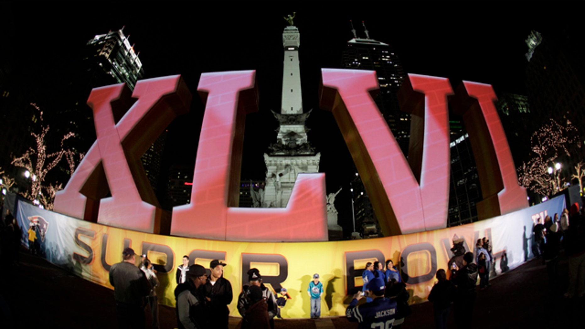 Feb. 1, 2012: In this photo taken with a fisheye lens, football fans pose for photos in front of the Super Bowl XLVI logo on Monument Circle in Indianapolis. The New England Patriots are scheduled to face the New York Giants in Super Bowl XLVI on Feb. 5.