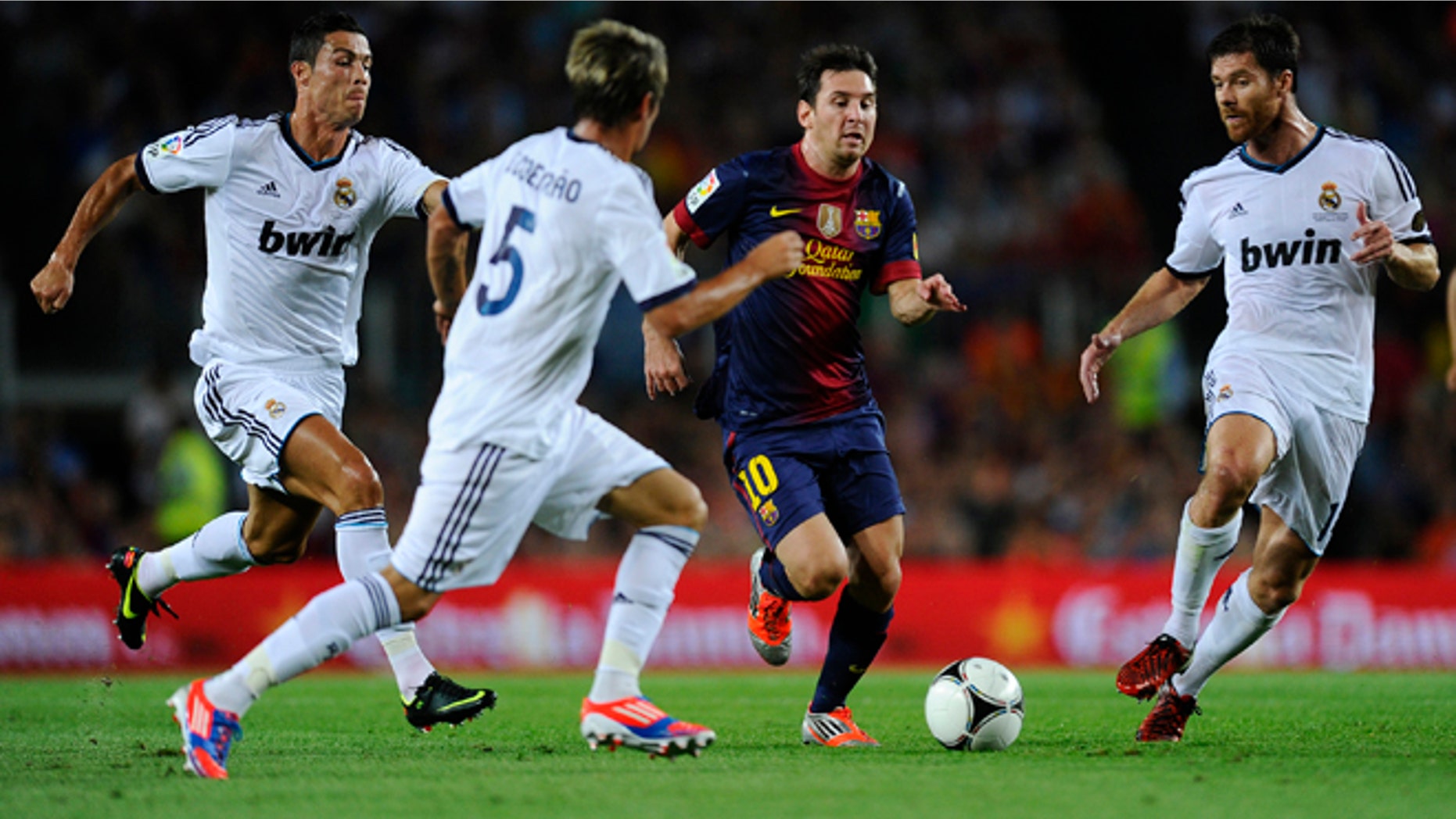 BARCELONA, SPAIN - AUGUST 23: Lionel Messi of FC Barcelona (2ndR) duels for the ball with Cristiano Ronaldo, Fabio Coentrao (2ndL) and Xabi Alonso of Real Madrid CF during the Super Cup first leg match between FC Barcelona and Real Madrid at Camp Nou on August 23, 2012 in Barcelona, Spain. (Photo by David Ramos/Getty Images)