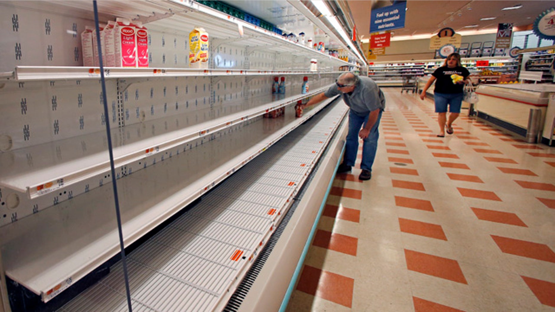 August 18, 2014: A shopper reaches into a mostly empty dairy shelf at Market Basket in Haverhill, Mass. (AP Photo/Elise Amendola)
