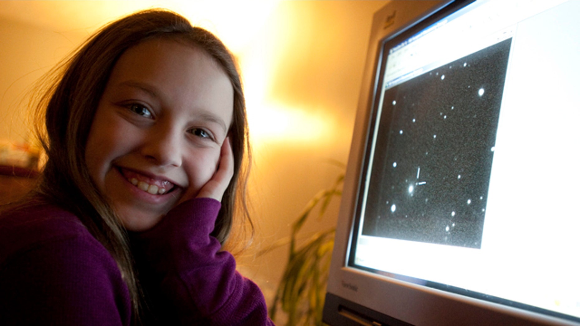 Ten-year-old Kathryn Gray sits next to a computer at the family's home in Birdton, New Brunswick, Canada, a suburb of Fredericton, on Monday, Jan. 3, 2011. On the computer monitor is an image in which she discovered a supernova. The Royal Astronomical Society of Canada says she made the discovery on the weekend under the watch of two other astronomers.