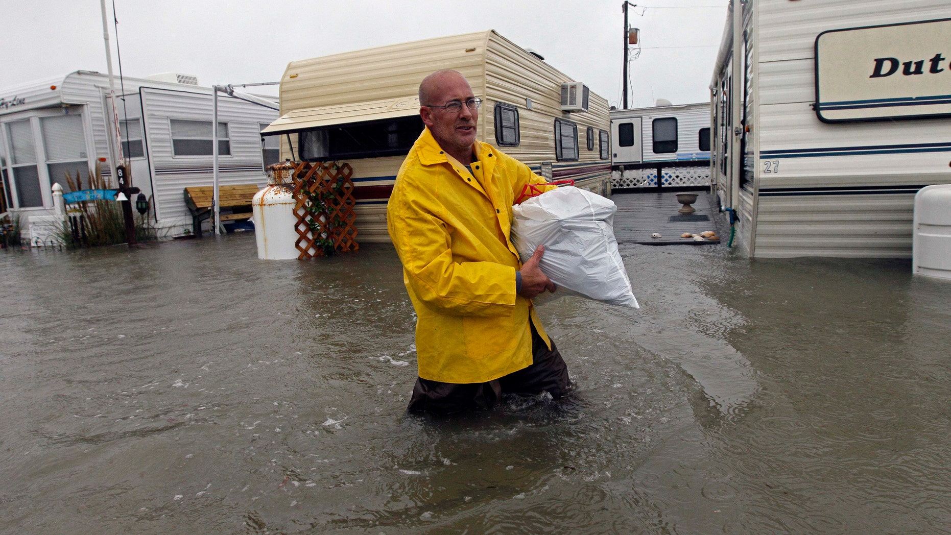 Oct. 29, 2012: Terry Robinson wades through water after retrieving some of his belongings from his flooded trailer at RV Park in Kitty Hawk, N.C., Monday.
