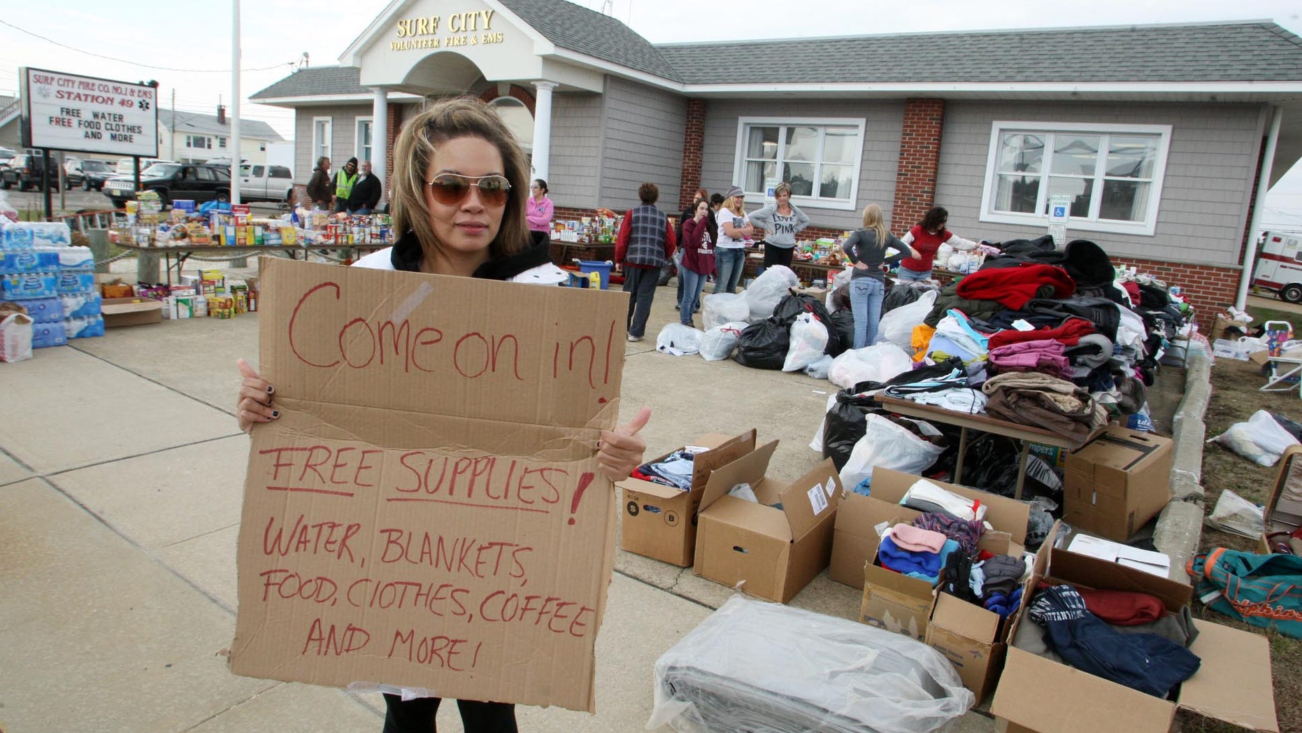 Nov. 10, 2012: Victoria Tribue, 21, volunteer member from Quakertown Pa., holds a sign advertising free supplies at the Surf City Volunteer Fire & EMS Station on Long Beach Island, N.J., after Superstorm Sandy.
