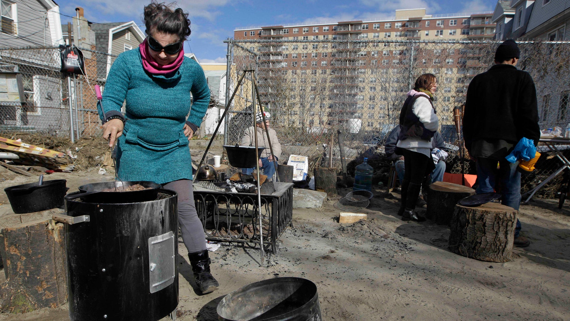Nov. 3, 2012: Kiva Kahl prepares beef stew for friends and neighbors in front of her residence in the Rockaways section of New York. More New Yorkers awoke Saturday to power being restored for the first time since Superstorm Sandy pummeled the region, but patience wore thin among those in the region who have been without power for most of the week.
