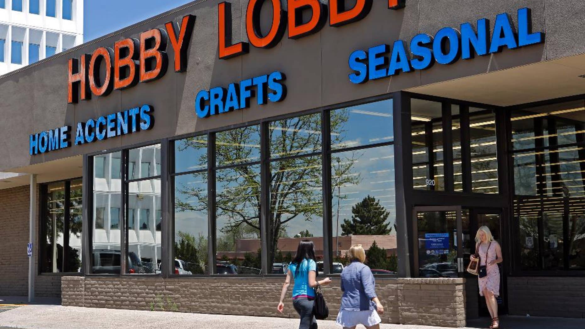 FILE - In this May 22, 2013, customers enter and exit a Hobby Lobby store in Denver. The Obama administration and its opponents are renewing the Supreme Court battle over President Barack Obama’s health care law in a case that pits the religious rights of employers against the rights of women to the birth control of their choice. Two years after the entire law survived the justices’ review by a single vote, the court is hearing arguments on Tuesday in a religion-based challenge from family-owned companies that object to covering certain contraceptives in their health plans as part of the law’s preventive care requirement. The largest company among them, Hobby Lobby Stores Inc. (AP Photo/Ed Andrieski, File)