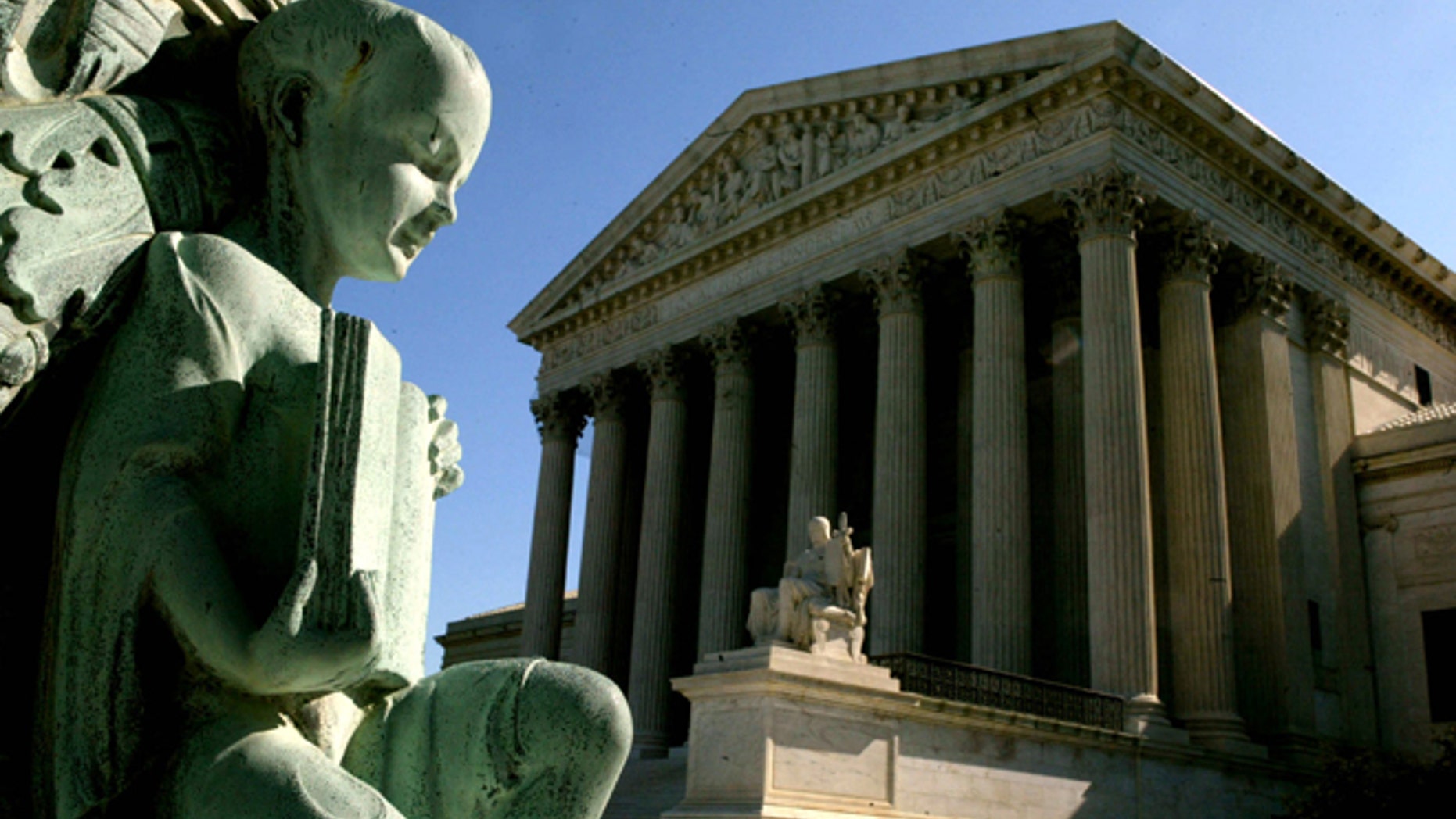 WASHINGTON - APRIL 28: A statue at the base of a flagpole stands outside the U.S. Supreme Court April 28, 2004 in Washington, DC. Today the high court heard arguments on the jailing of American citizens suspected of links to terrorism and denying them access to lawyers and courts. (Photo by Mark Wilson/Getty Images)