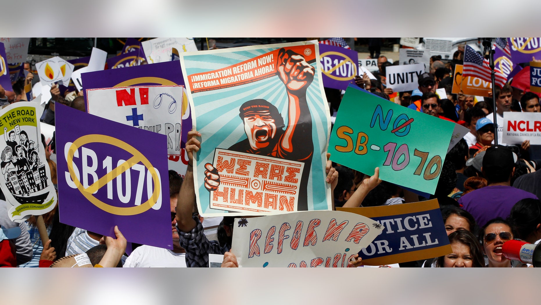 Supporters of immigrant rights rally outside the Supreme Court in Washington, Wednesday, April 25, 2027, where the court held a hearing on Arizona's "show me your papers" immigration law. (AP Photo/Charles Dharapak)
