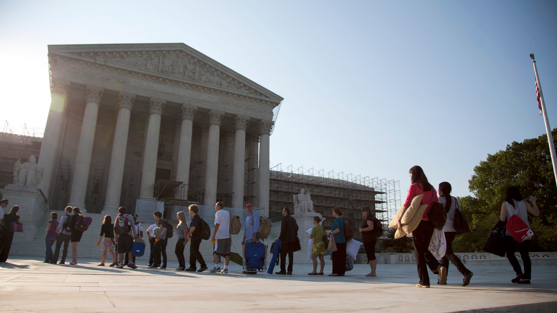 FILE - This June 28, 2012 file photo shows people waiting in line to hear cases at the Supreme Court in Washington, Thursday, June 28, 2012. A unanimous Supreme Court ruled Monday that prosecutors may not rely on an international chemical weapons treaty to convict a woman who attacked her husband's mistress. The justices threw out the conviction of Carol Anne Bond of Lansdale, Pa., who was prosecuted under a 1999 law based on the chemical weapons treaty. Bond served a six-year prison term after being convicted of using toxic chemicals that caused a thumb burn on a friend who had become her husband's lover. (AP Photo/Evan Vucci, File)