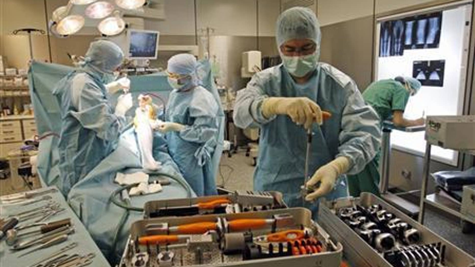Surgeons perform a total knee arthroplasty operation in an operating room at the Ambroise Pare hospital in Marseille, southern France, April 14, 2008. REUTERS/ Jean-Paul Pelissier