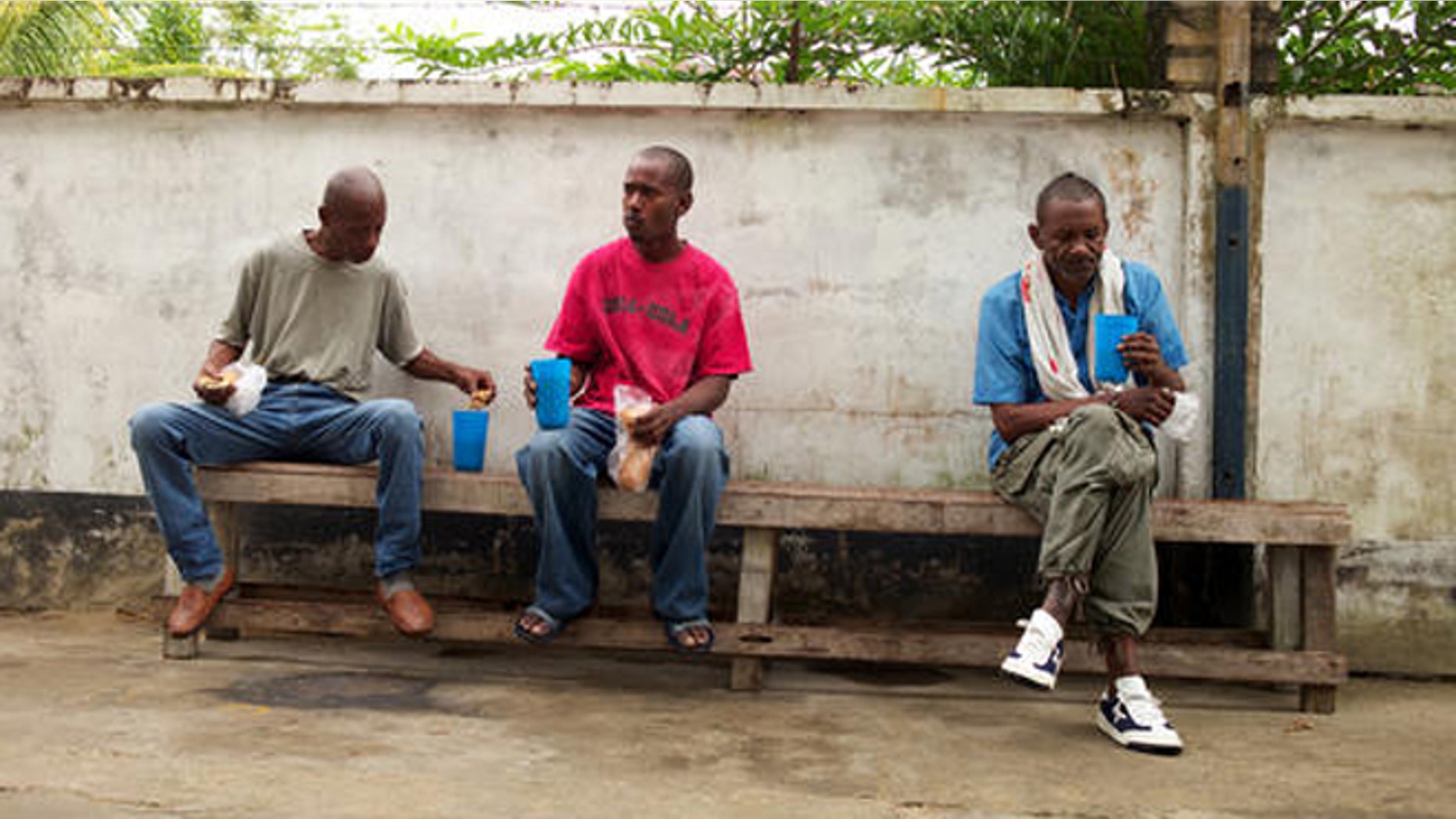 FILE - In this Jan. 27, 2014 file photo, homeless men eat breakfast at a shelter for the homeless in Paramaribo, Suriname. Life has become exceedingly hard in Suriname in 2016, where the economy has been in free-fall amid the collapse of global commodity prices and the slide of the local currency relative to the U.S. dollar. (AP Photo/Ertugrul Kilic, File)