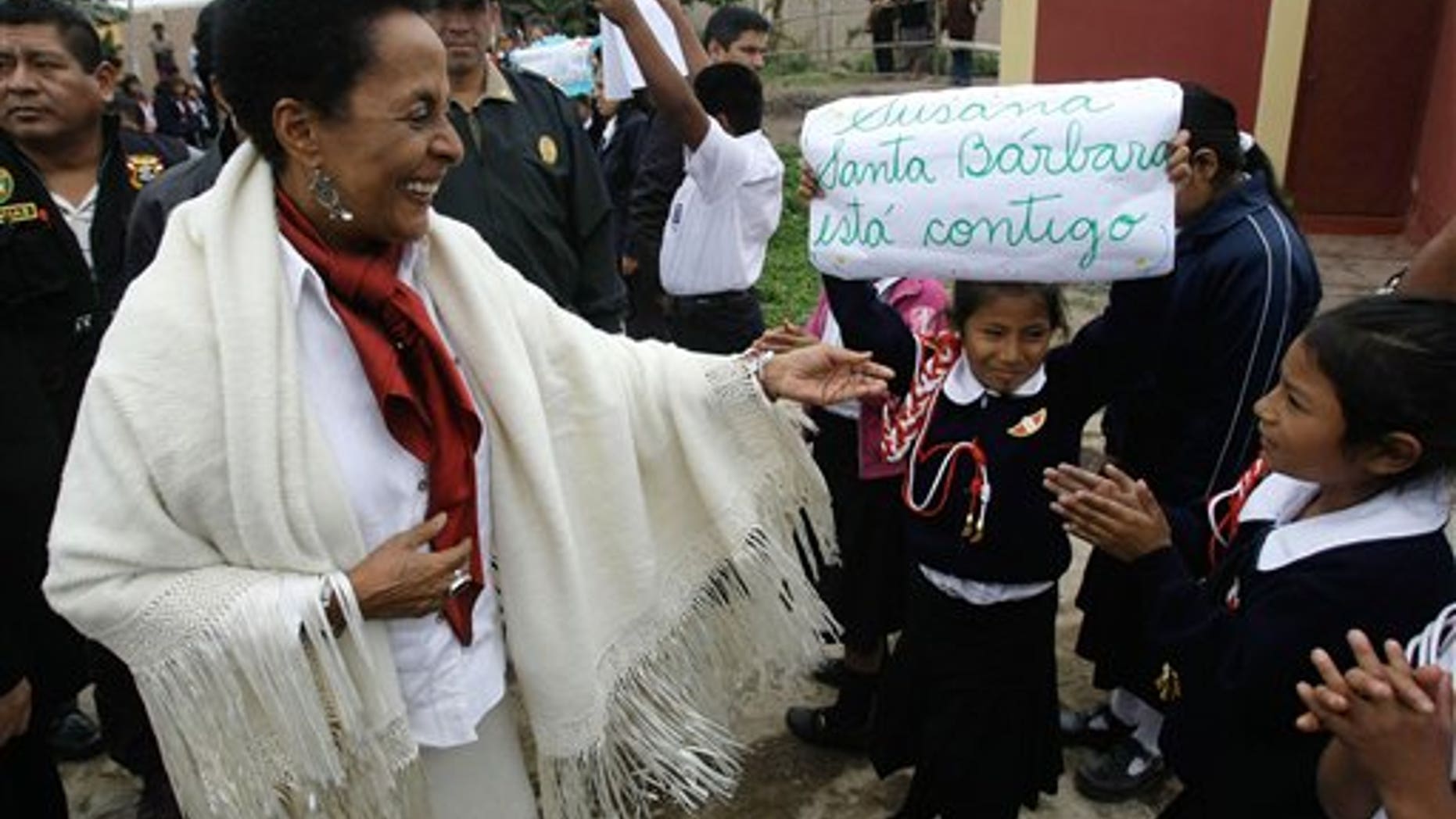 In this photo taken Aug. 29, 2011, Peru's Culture Minister Susana Baca greets students during a visit to a school in San Luis de Canete, Peru. Baca, 67, is living testimony to Afro-Peruvians' enduring struggle and she is determined to end the discrimination that made second-class citizens not just of blacks but also of Peru's indigenous. Baca became the Andean nation's first black Cabinet minister in July 2011. (AP Photo/Karel Navarro)