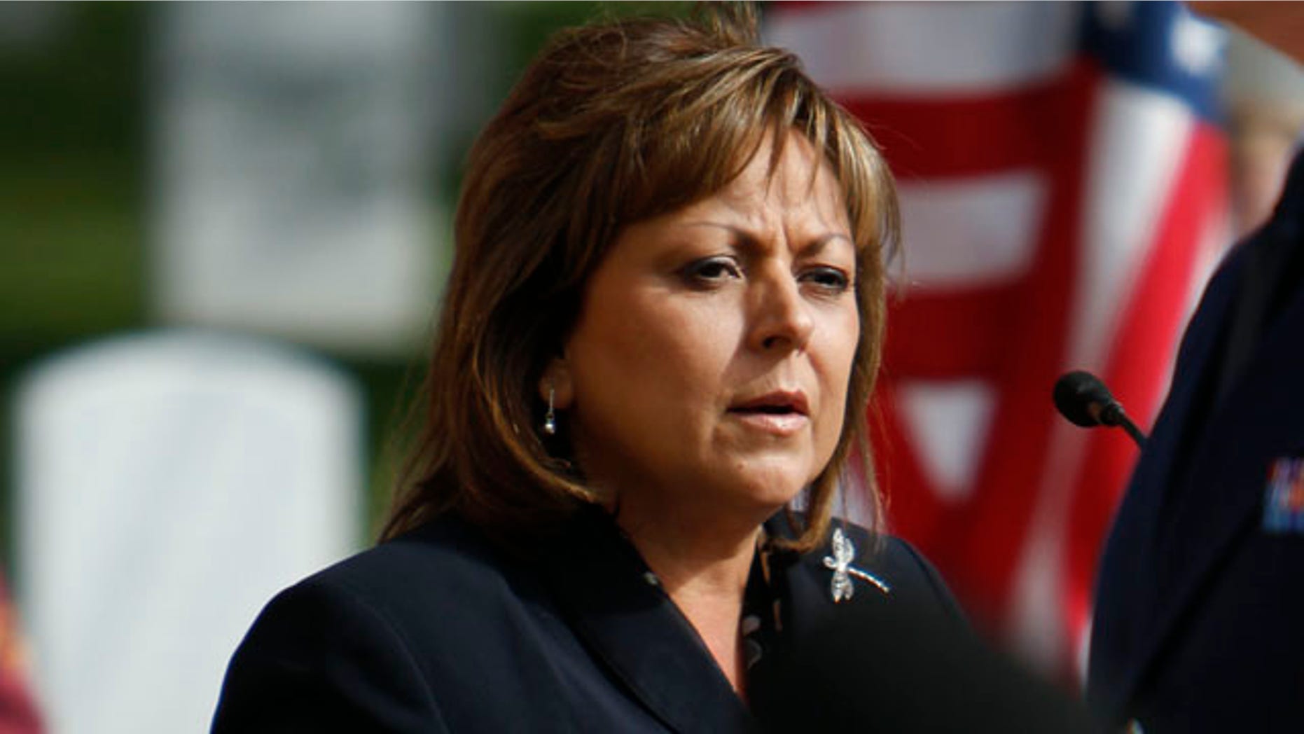 In this Tuesday Nov. 1, 2011 photo, Gov. Susana Martinez speaks during the memorial service for 10 veterans at the Santa Fe National Cemetery as part of the Missing in America Project. According to the web site, the purpose of the MIA Project is to locate, identify and inter the unclaimed cremated remains of American veterans through the joint efforts of private, state and federal organizations. The services were in memory of retired Col. John Garnett Coughlin, retired Col. Jackson Evert Shirley, retired Lt. Edward Grimm Lucius, Chief Petty Officer Donald Claire Smith, Petty Officer 2nd Class Milton Vincin Burroughs, Technician Third Class Gerald Edwin Huber, Technician Third Class Richard Landrum Thomas, Airman 1st Class Charles Thomas Stewart, Pvt. John L. Craft, and Pvt. Hanry D. Nichols. (AP Photo/The Santa Fe New Mexican, Luis Sanchez Saturno)