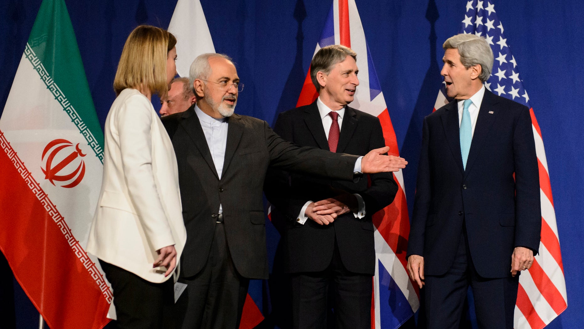 FILE - In this file photo taken Thursday, April 2, 2015, from left, EU High Representative for Foreign Affairs and Security Policy, Federica Mogherini, Iranian Foreign Minister, Mohammad Javad Zarif, British Foreign Secretary, Philip Hammond, and U.S. Secretary of State, John Kerry, line up for a press announcement after a new round of Nuclear Iran Talks in the Learning Center at the Swiss federal Institute of Technology (EPFL) in Lausanne, Switzerland.